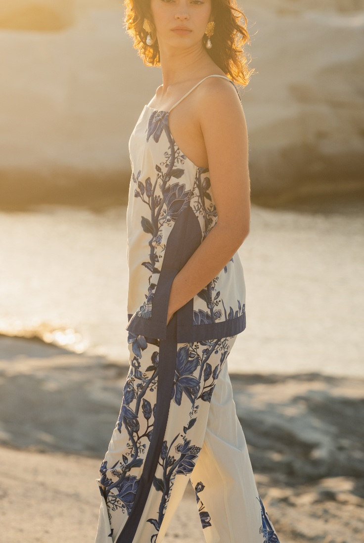 Woman in a floral matching set standing on a beach with a blurred background Calling June
