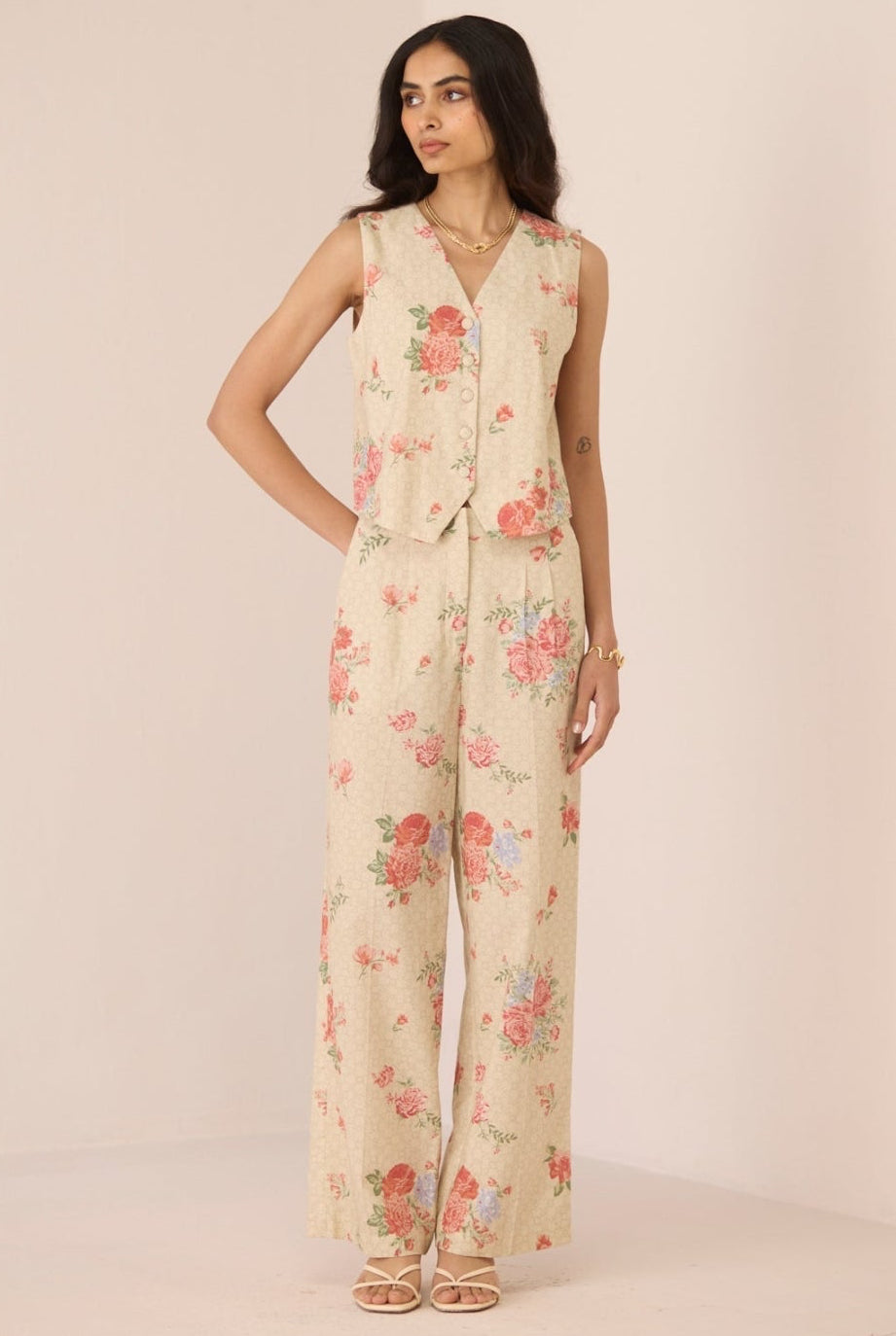 Woman wearing a floral jumpsuit on a plain background Calling June