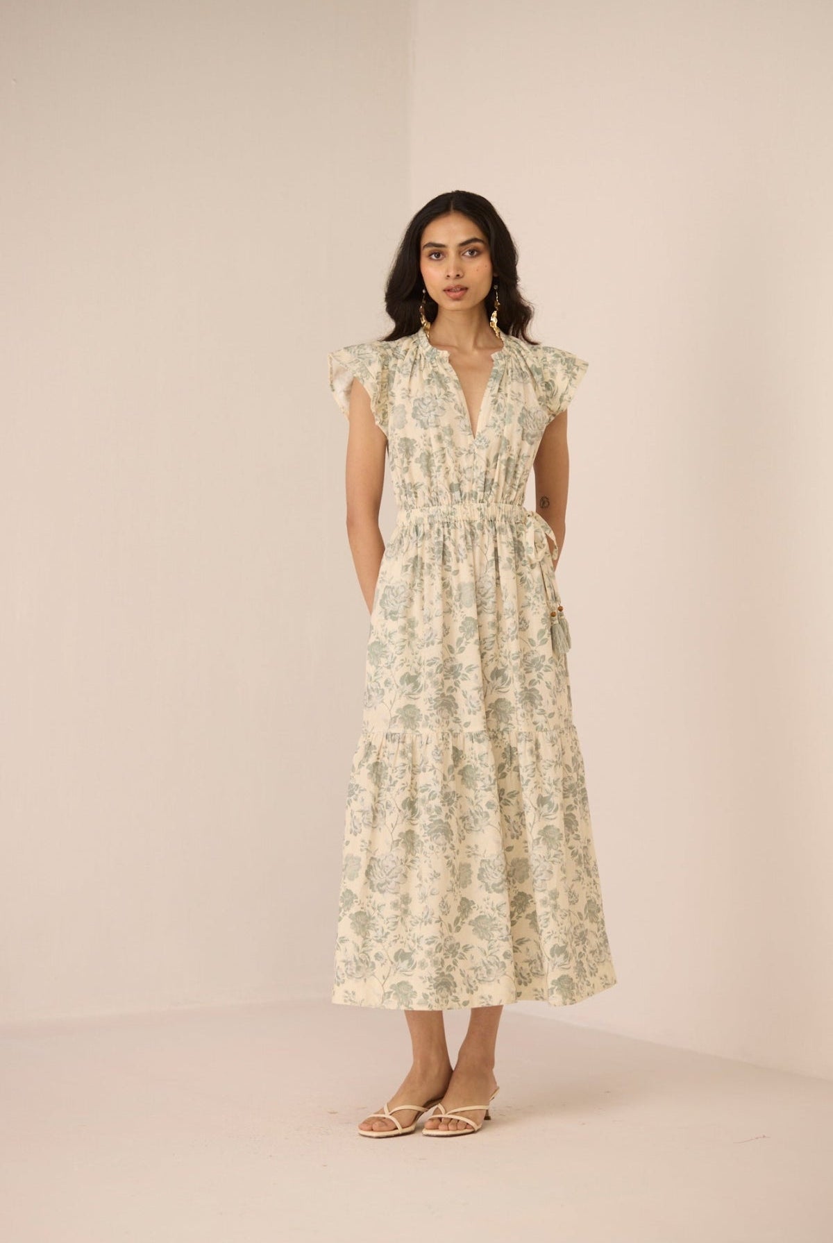 Woman wearing a floral dress against a plain background Calling June