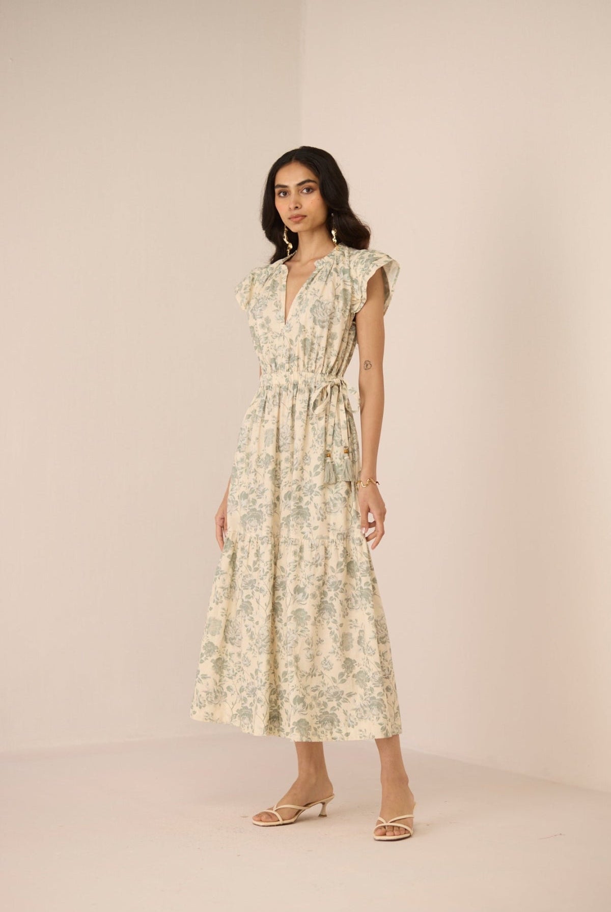 Woman wearing a floral dress against a plain background Calling June