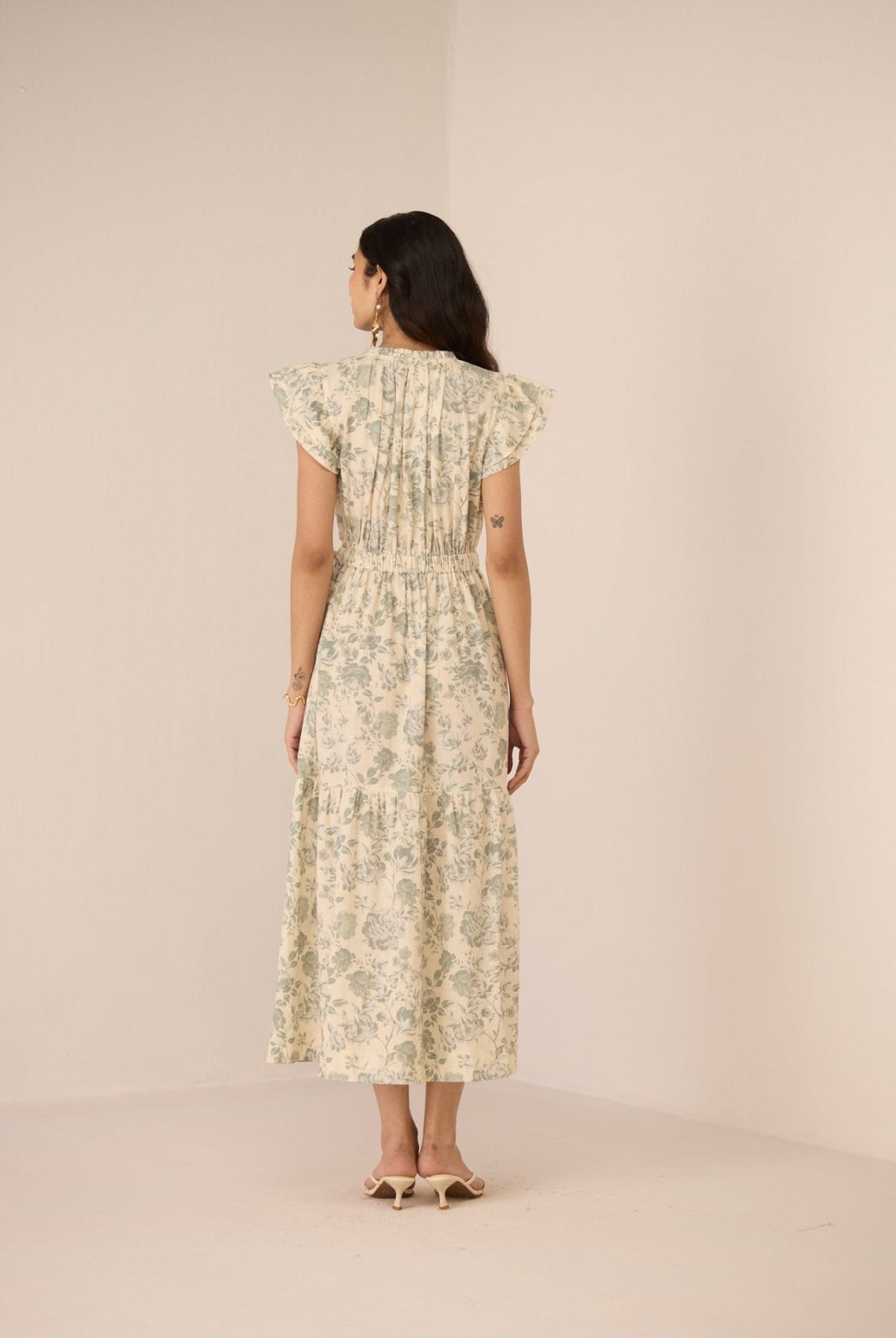 Woman wearing a floral dress against a beige background Calling June