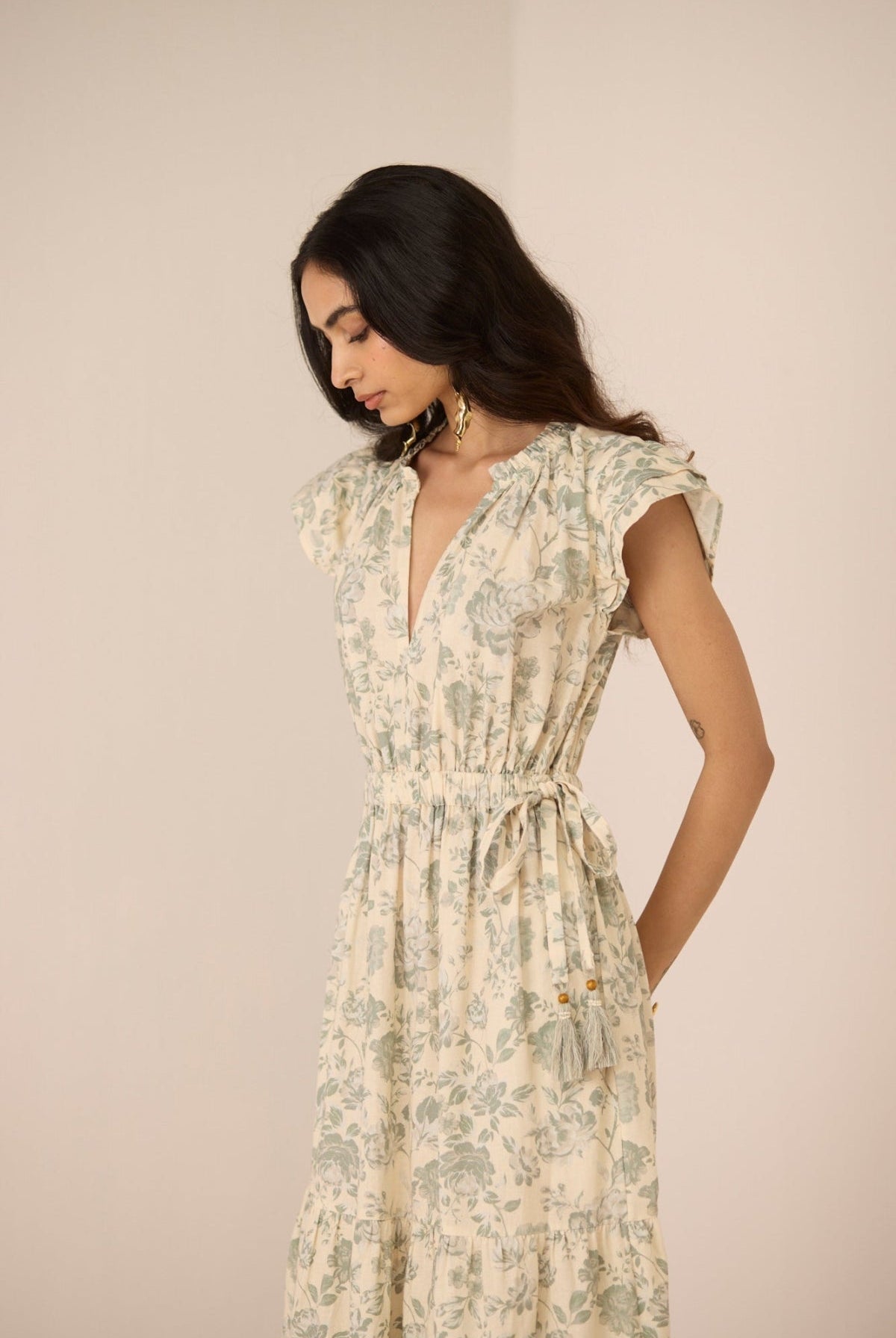 Woman wearing a floral dress against a plain background Calling June
