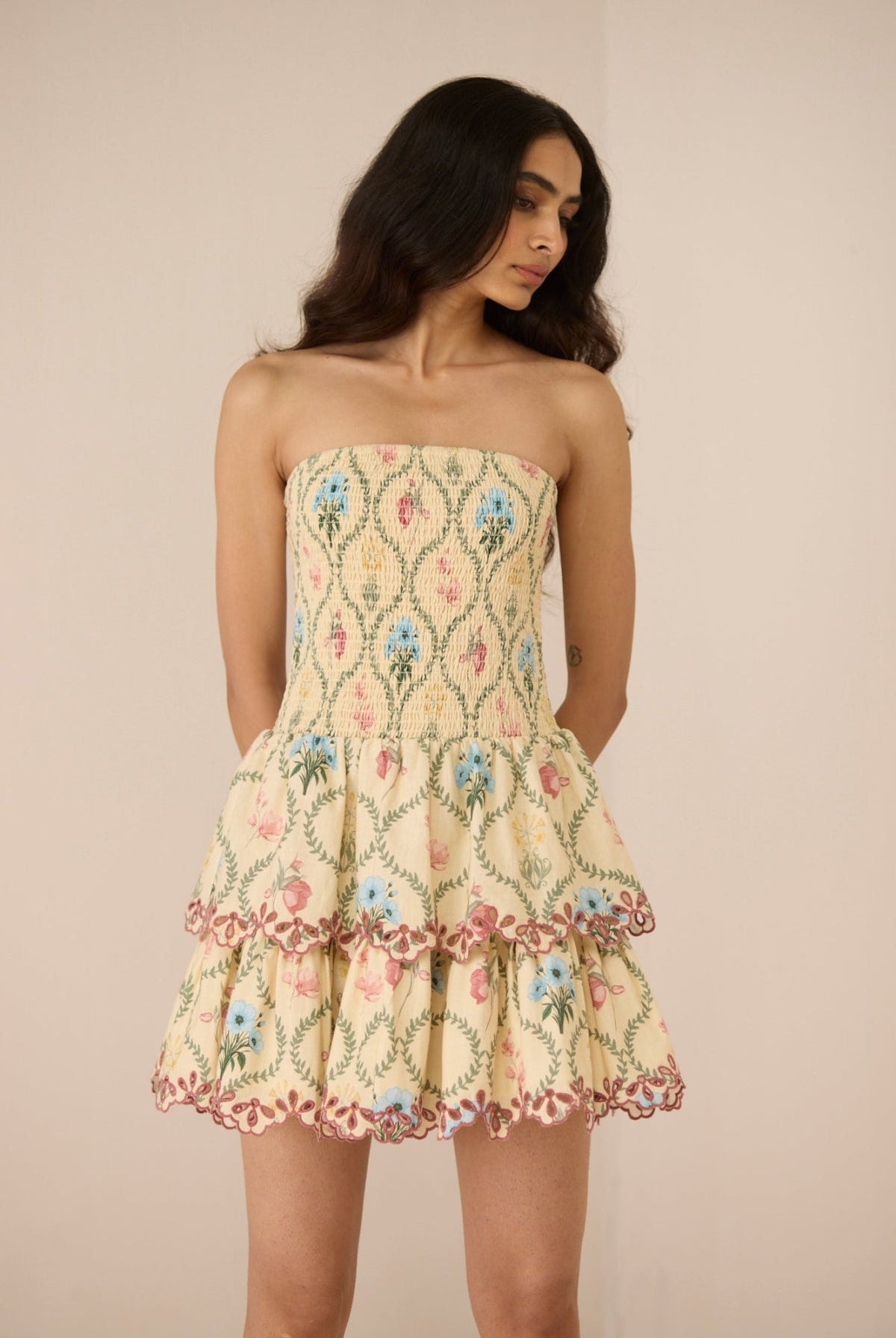 Woman wearing a floral strapless dress against a beige background Calling June