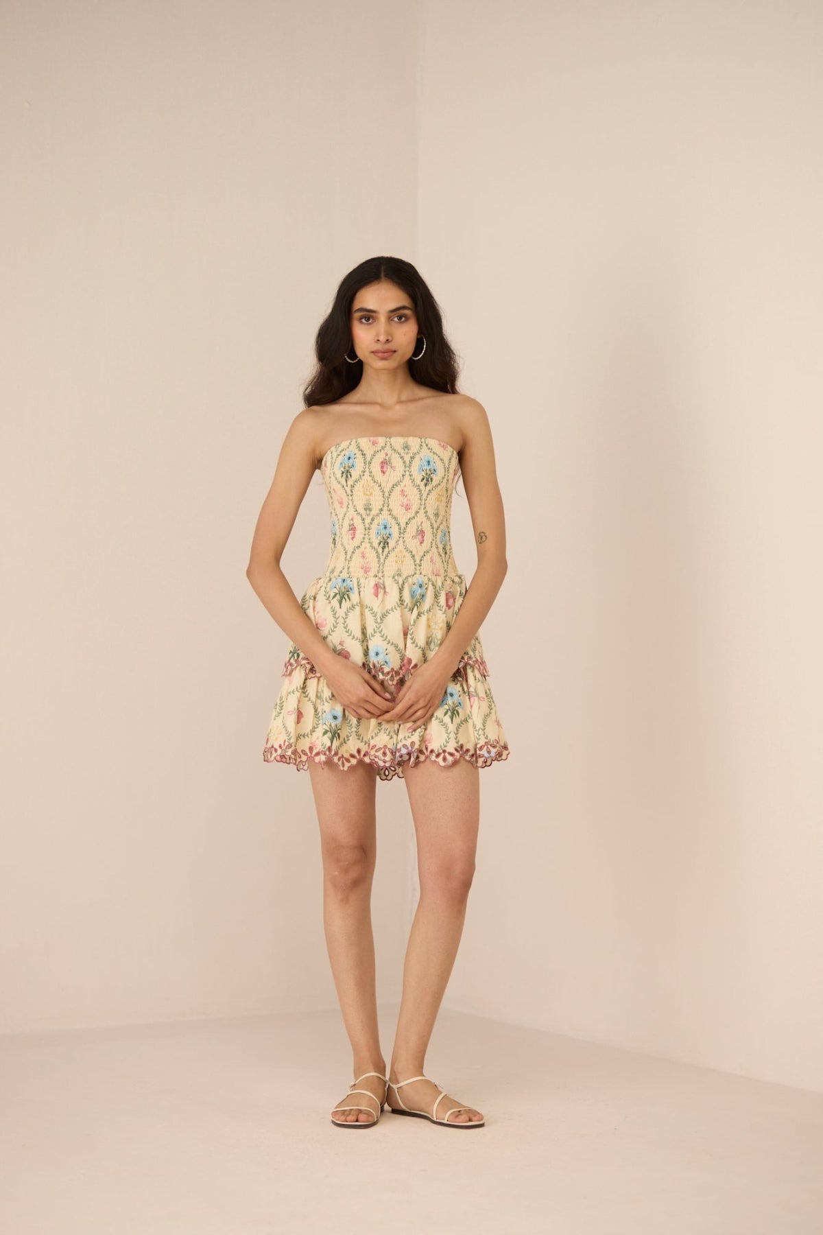 Woman wearing a strapless floral dress against a beige background Calling June