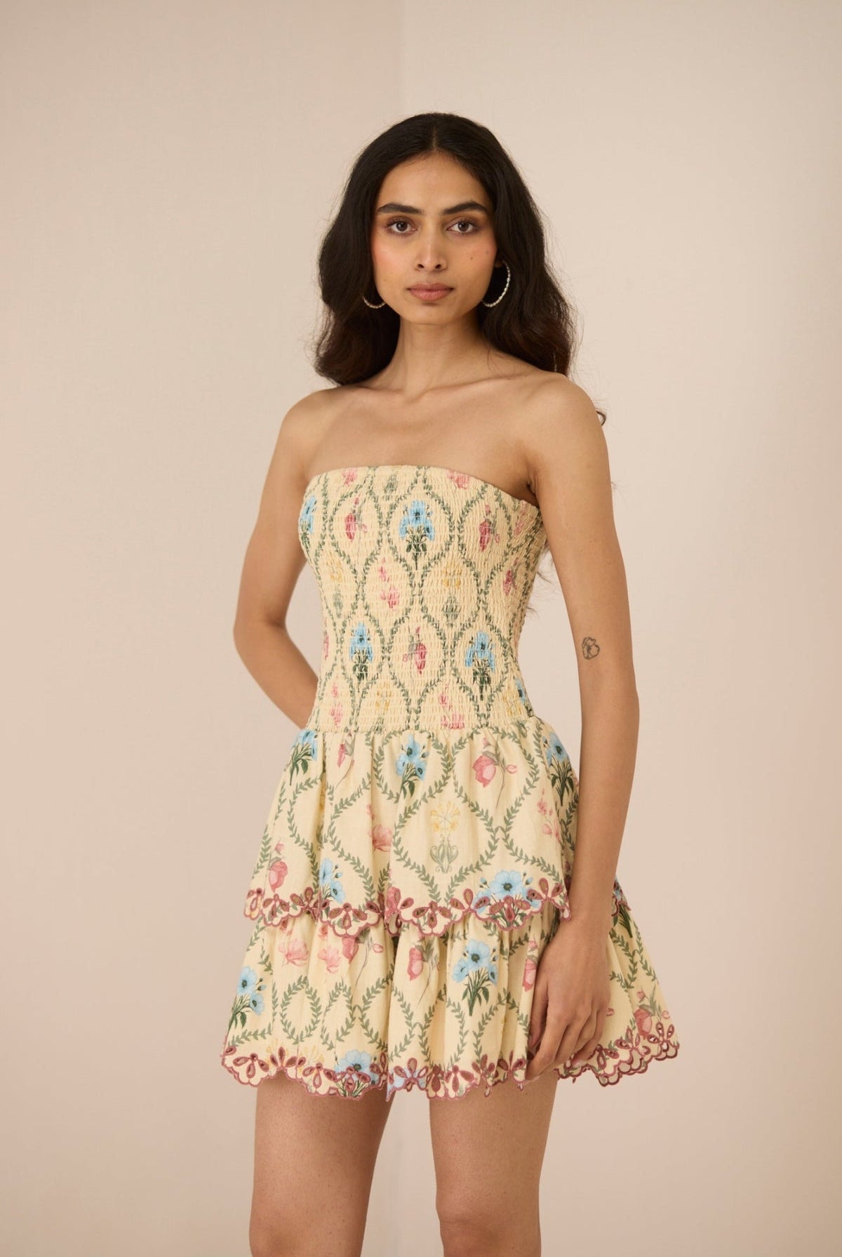 Woman wearing a strapless floral dress against a beige background Calling June