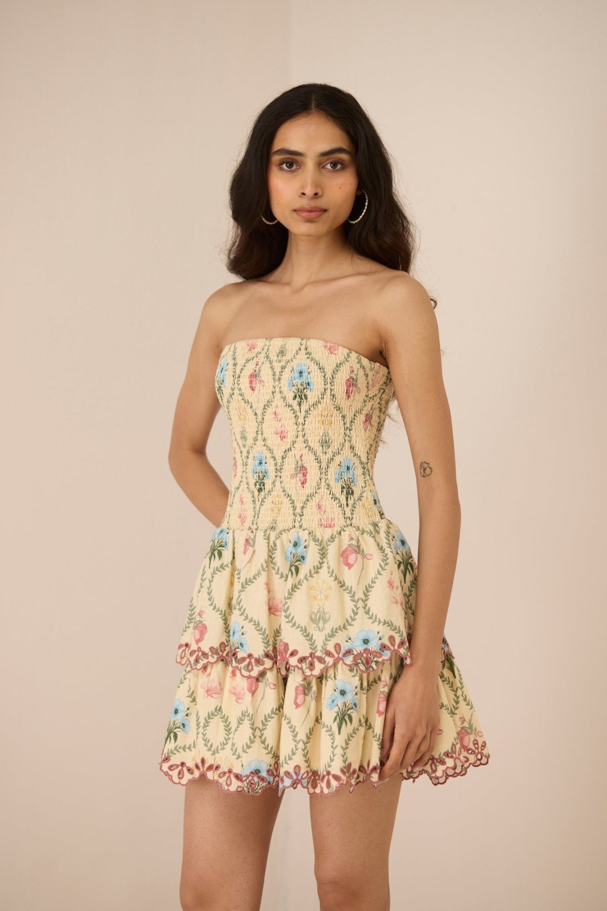 Woman wearing a strapless floral dress against a beige background Calling June