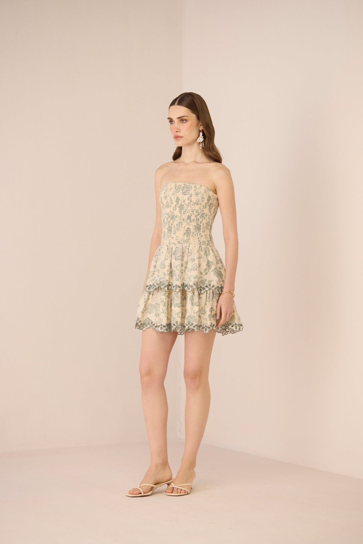 Woman wearing a strapless floral dress on a beige background Calling June