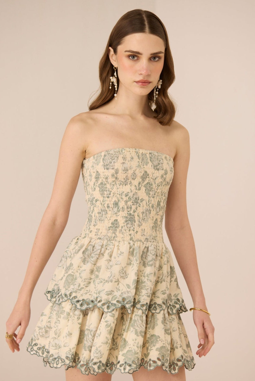 Woman wearing a strapless floral dress against a beige background Calling June