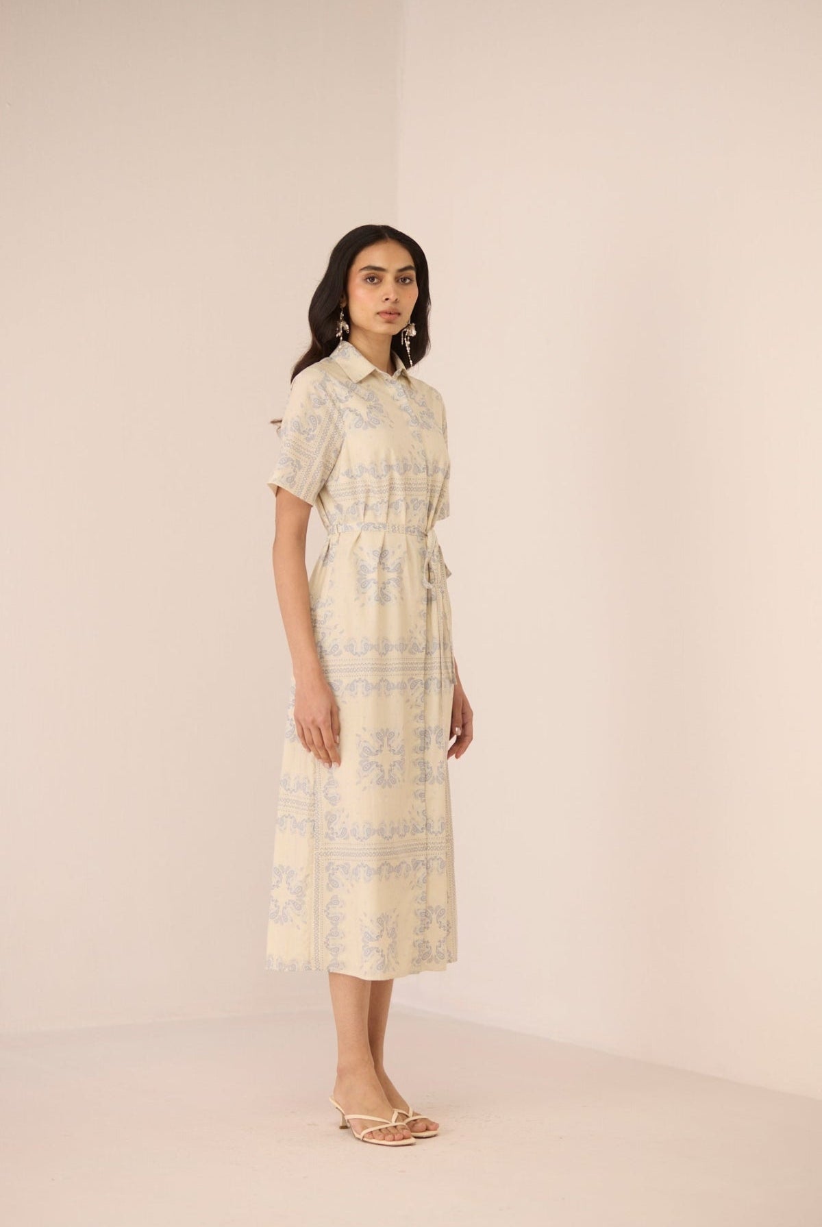 Woman wearing a patterned dress on a plain background Calling June