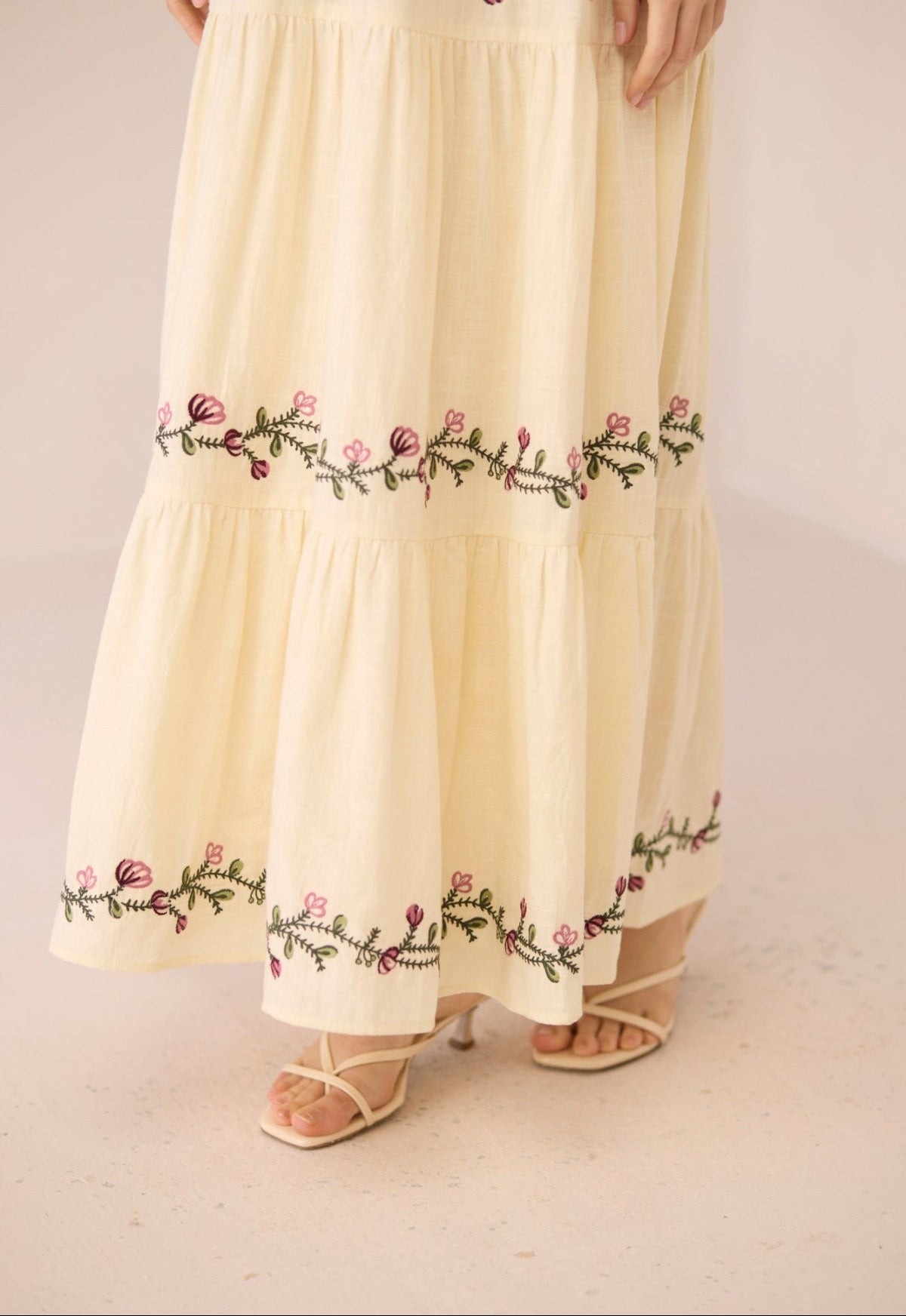 Beige skirt with floral embroidery on a plain background Calling June