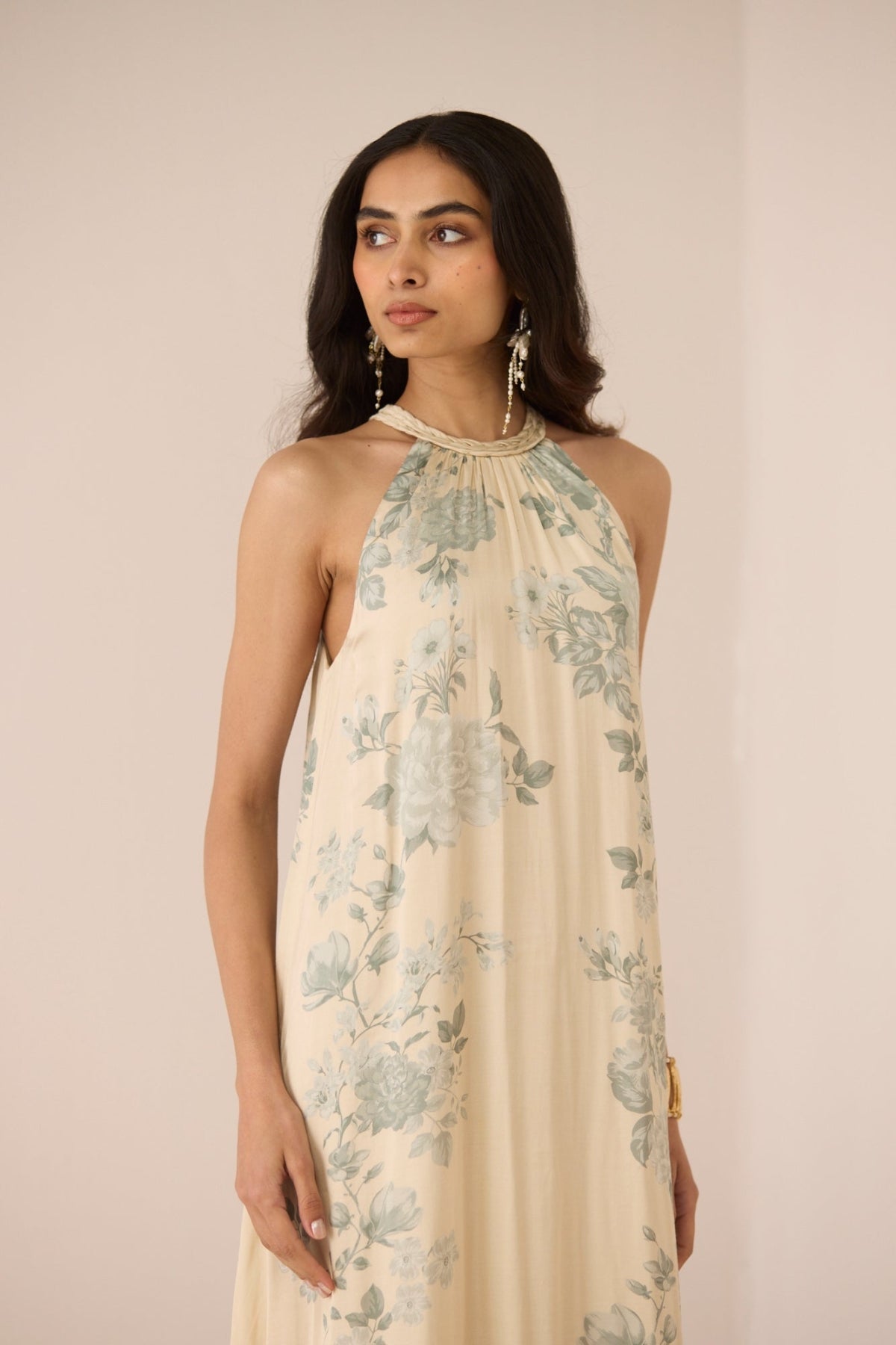 Woman wearing a floral dress against a plain background Calling June