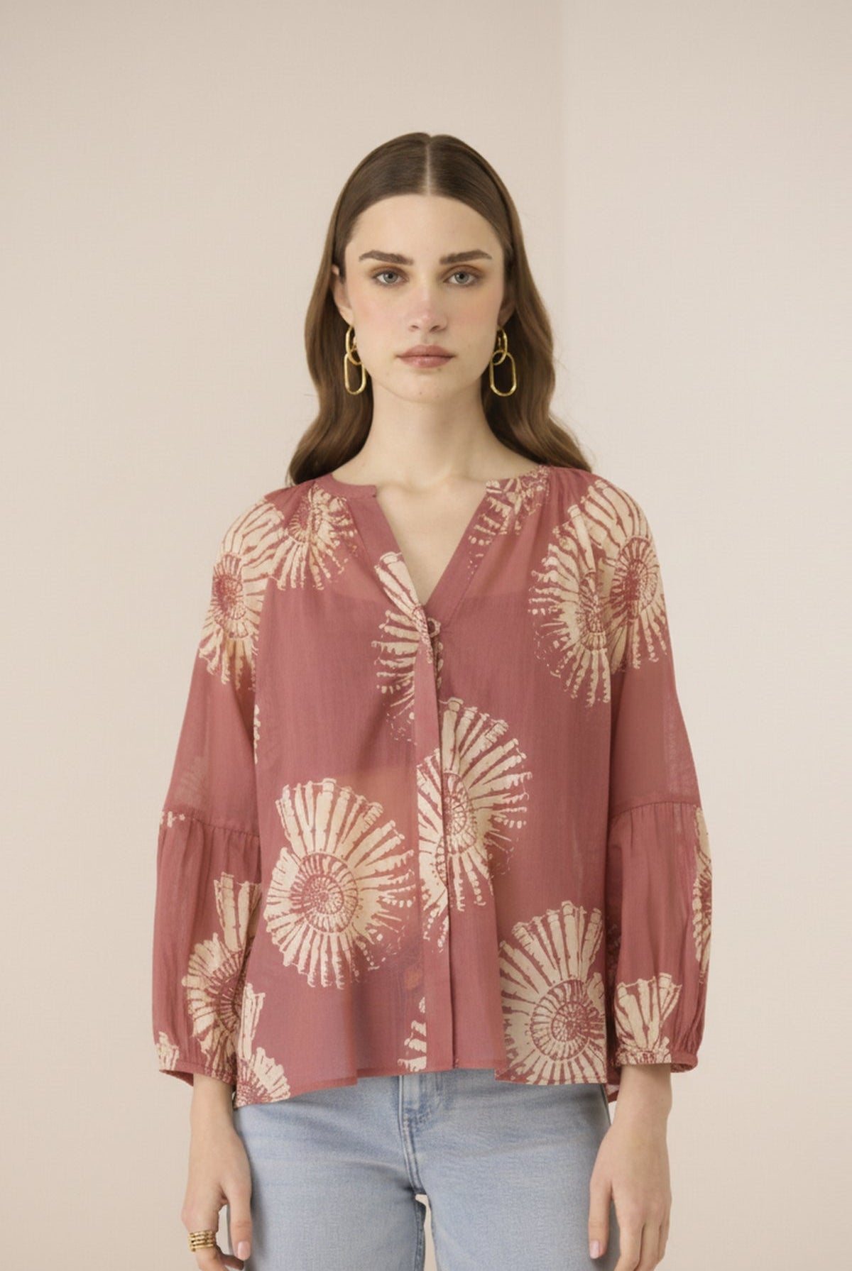 Woman wearing a patterned blouse with a plain background Calling June