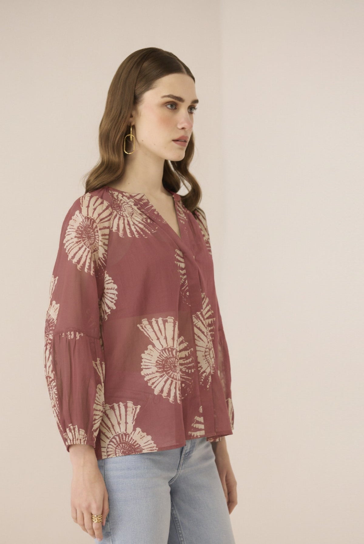 Woman wearing a patterned blouse with a plain background Calling June