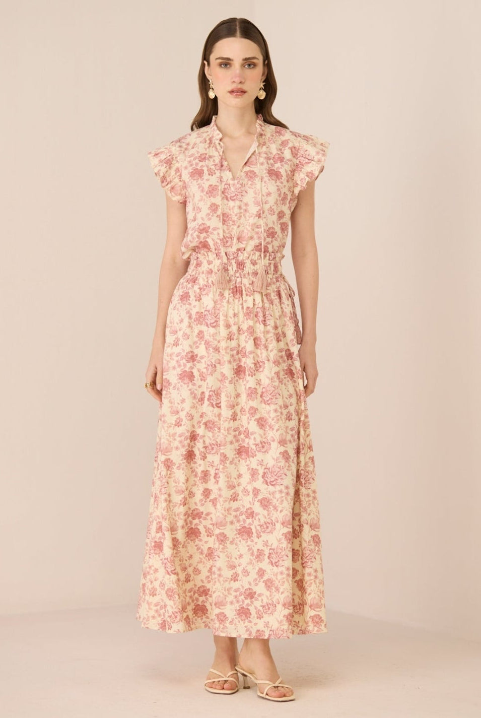 Woman wearing a floral dress on a beige background Calling June