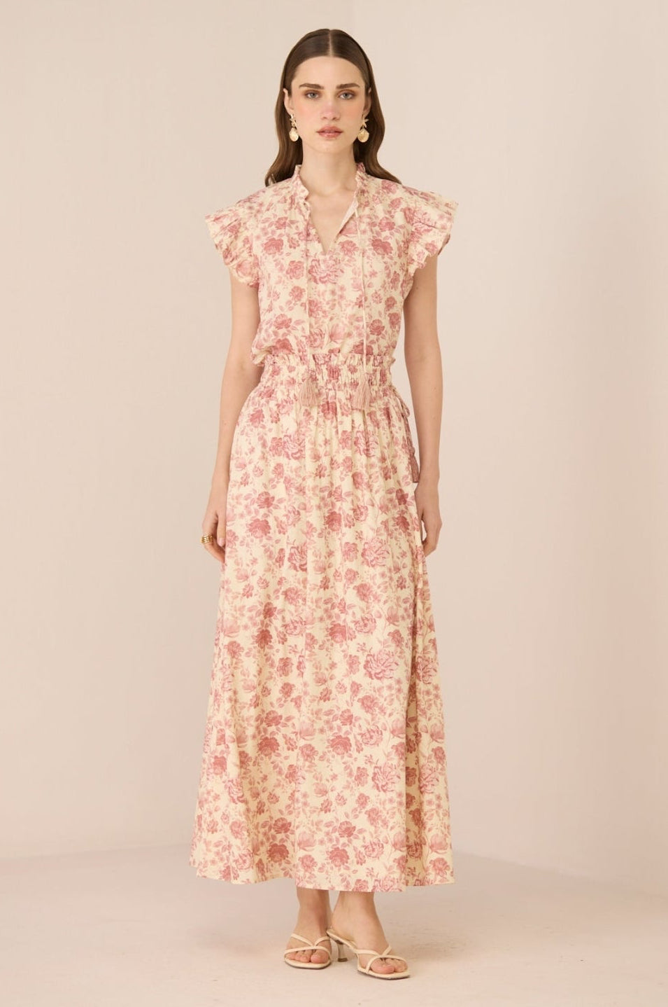 Woman wearing a floral dress on a beige background Calling June