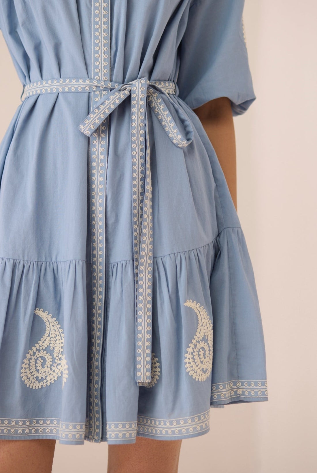 Light blue dress with white embroidery on a beige background Calling June