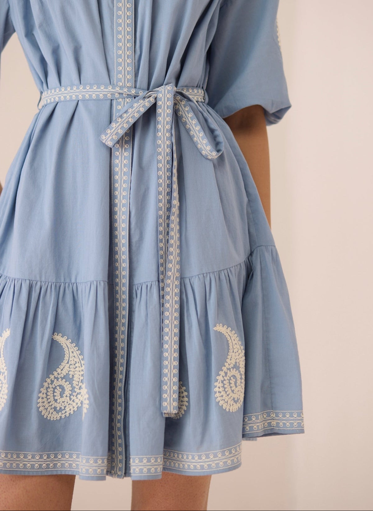 Light blue dress with white embroidery on a beige background Calling June