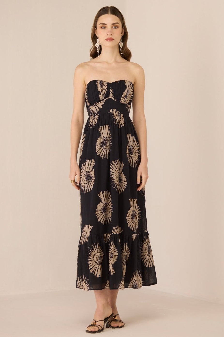 Woman wearing a strapless dress with floral pattern on a beige background Calling June