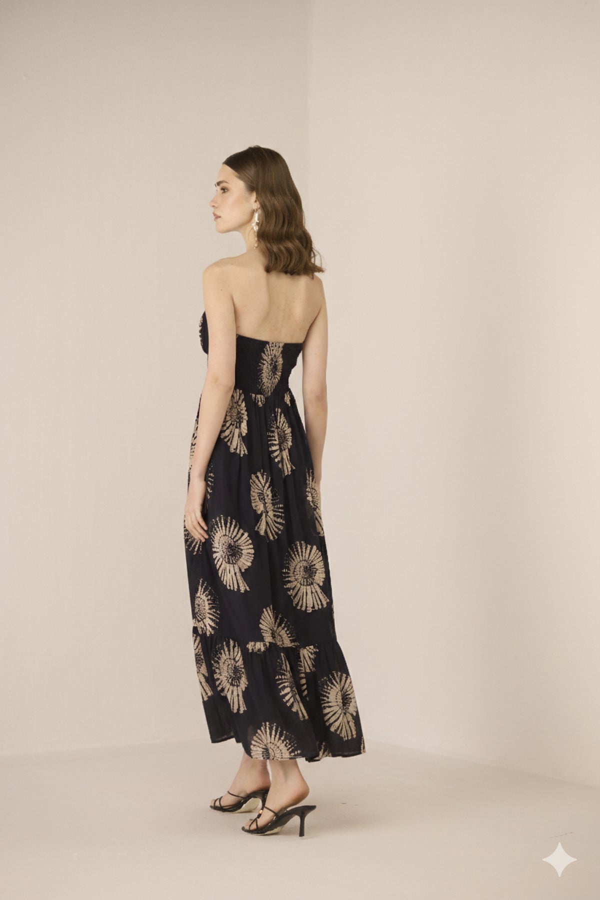 Woman wearing a black floral dress against a beige background Calling June