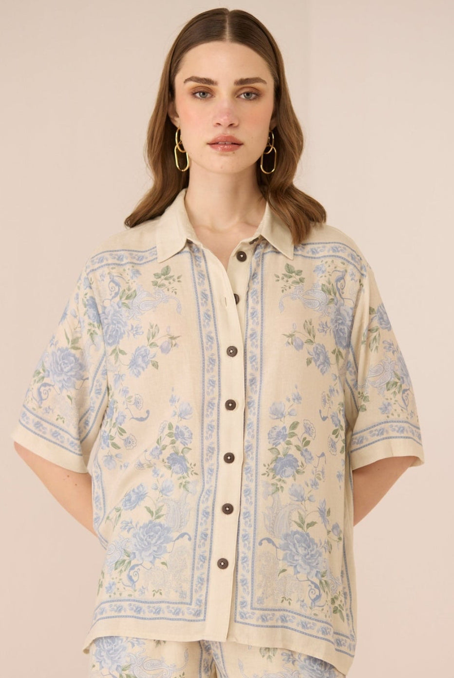 Woman wearing a floral patterned outfit on a beige background Calling June