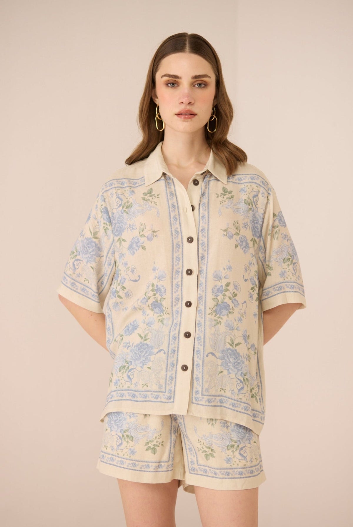 Woman wearing a floral patterned outfit on a beige background Calling June