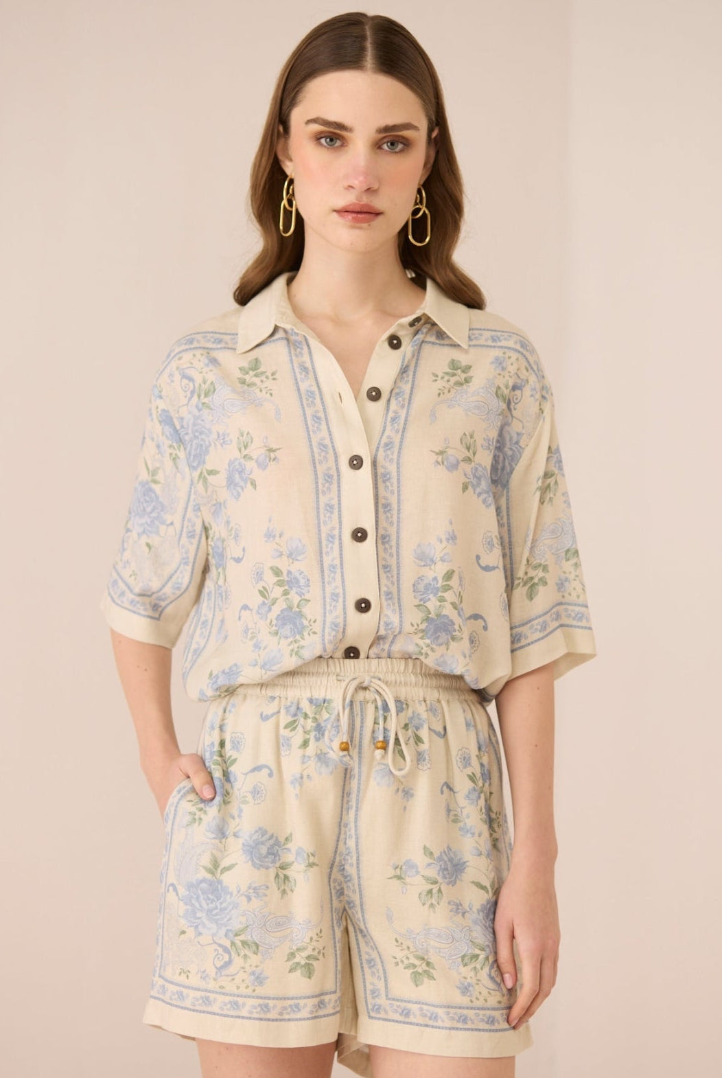 Woman wearing a floral outfit on a beige background Calling June