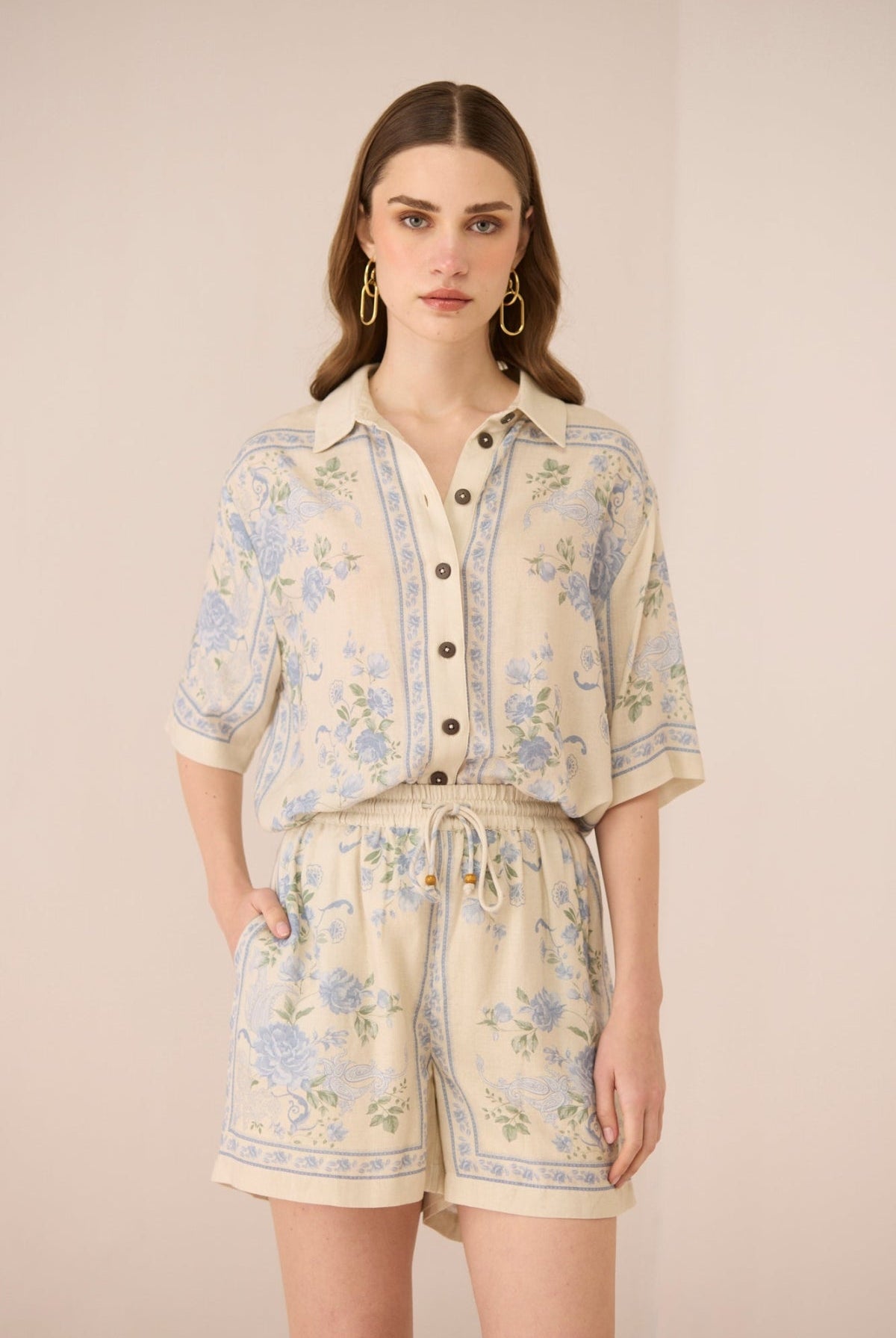 Woman wearing a floral outfit on a beige background Calling June