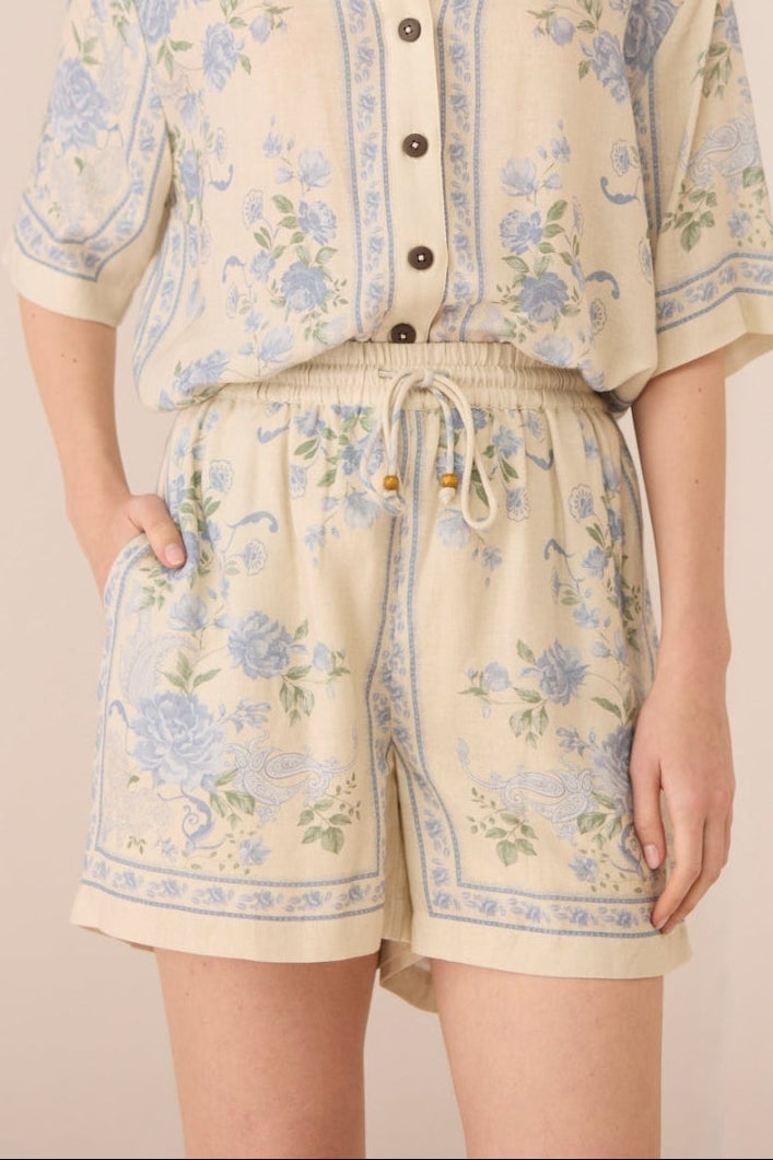 Woman wearing a floral outfit on a beige background Calling June