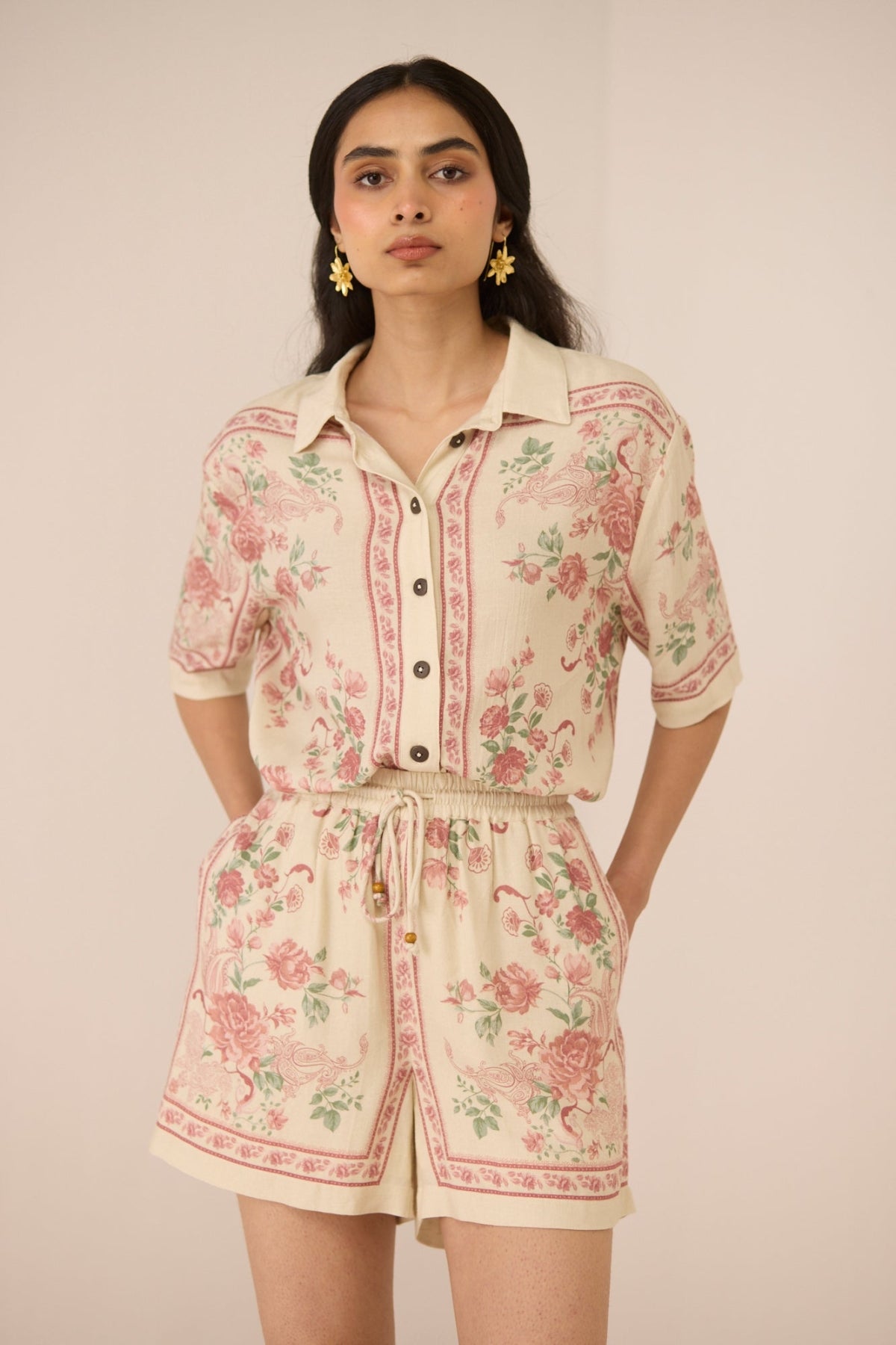 Woman wearing a floral romper against a plain background Calling June
