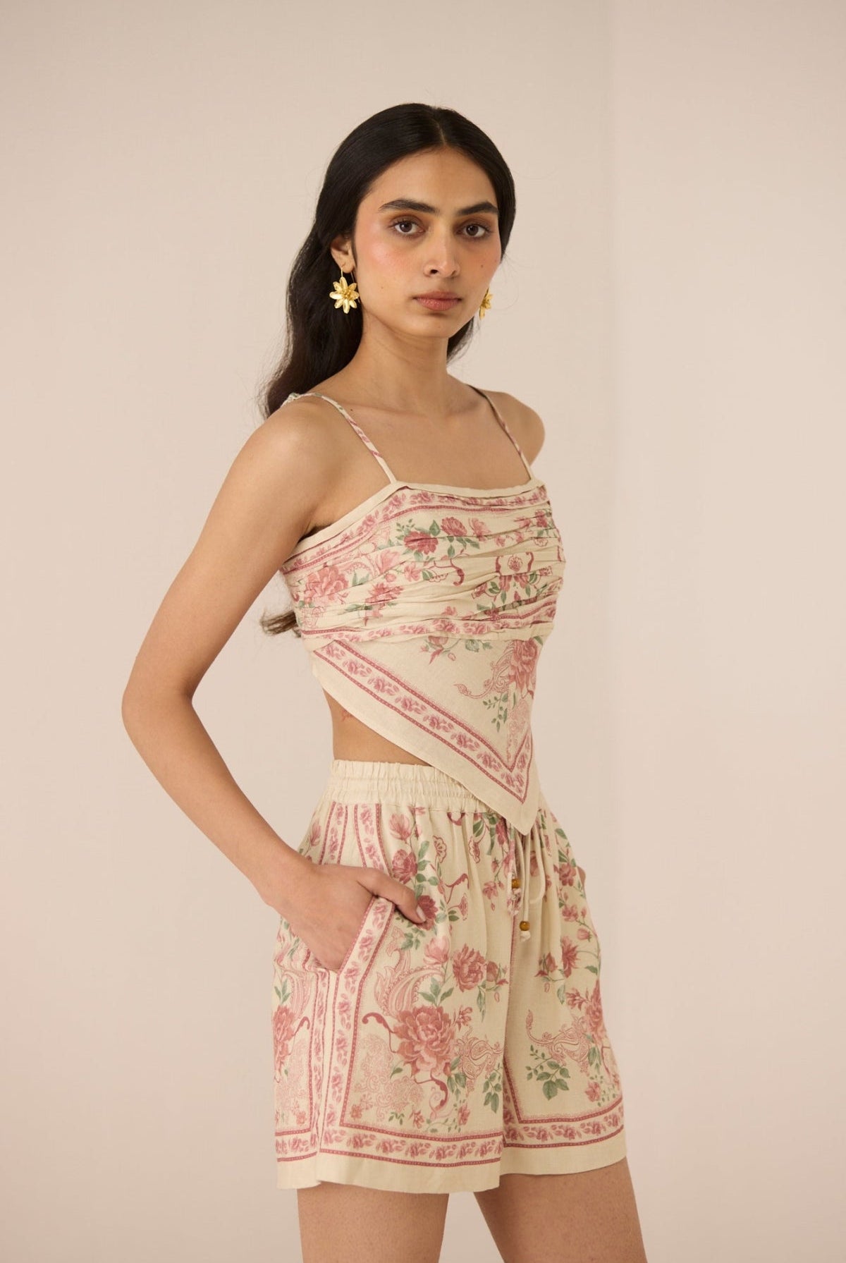 Woman wearing a floral two-piece outfit against a plain background Calling June