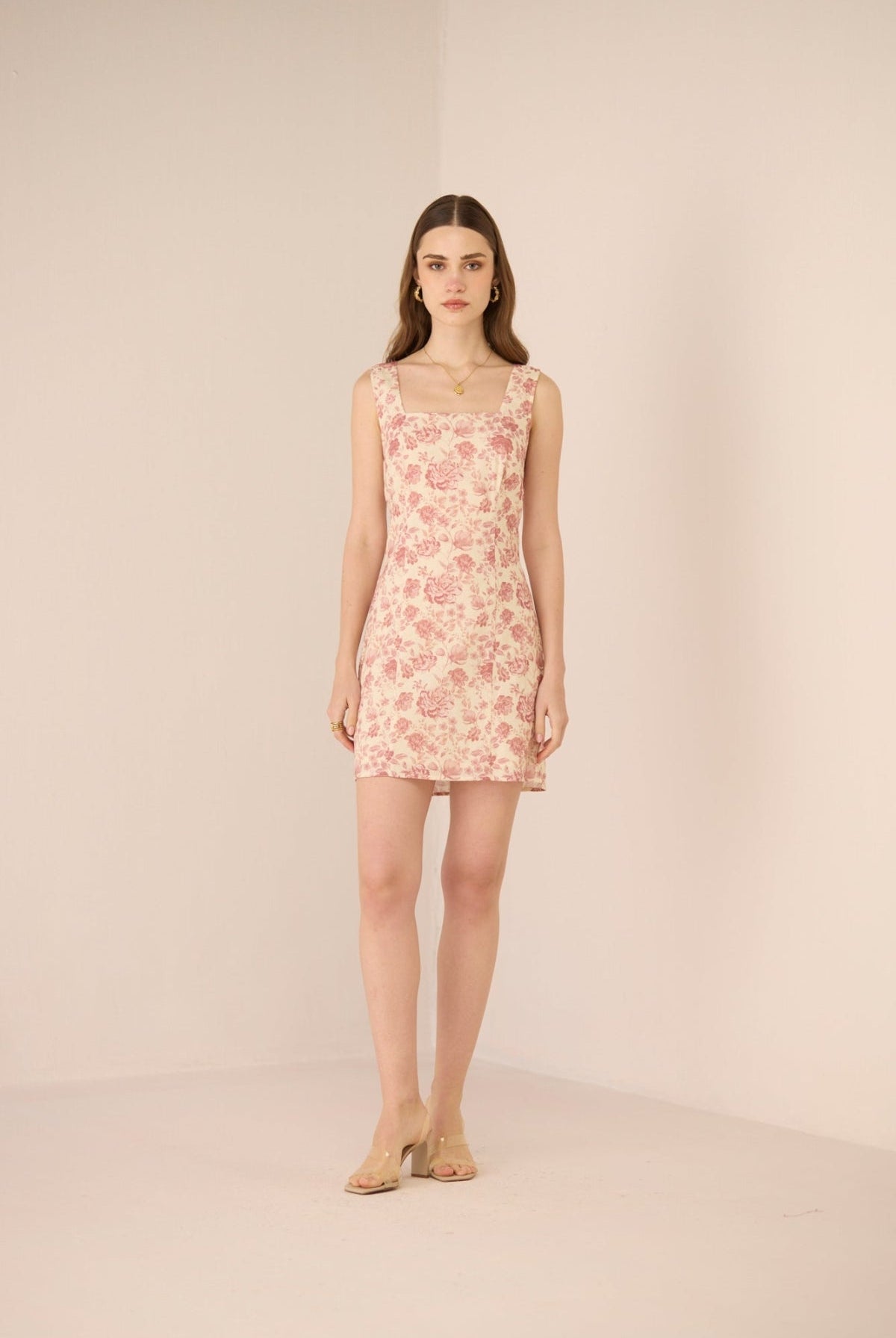 Woman wearing a floral dress against a plain background Calling June