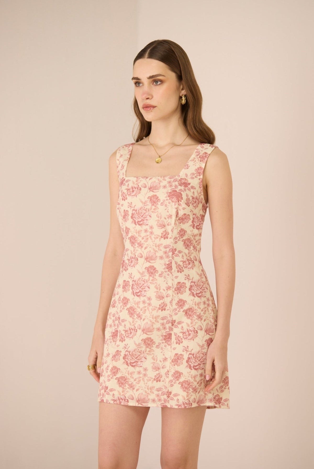 Woman wearing a floral dress against a plain background Calling June