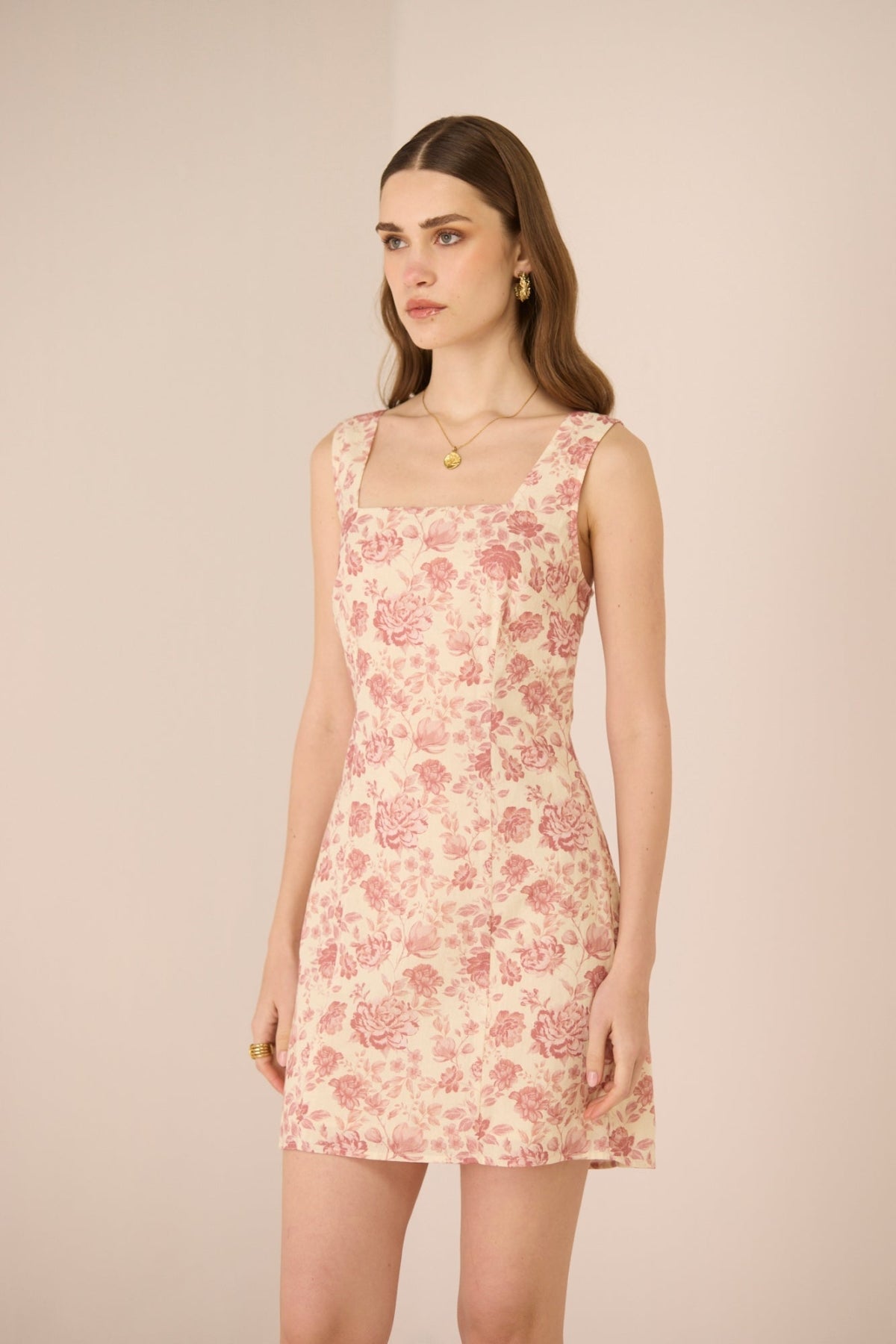 Woman wearing a floral dress against a plain background Calling June