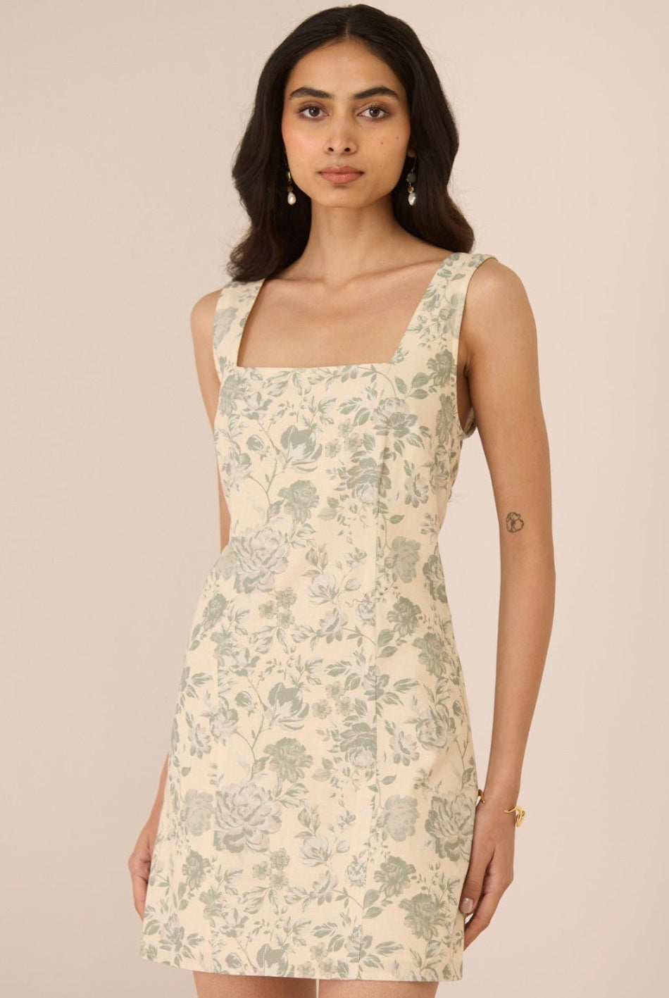 Woman wearing a floral dress against a plain background Calling June