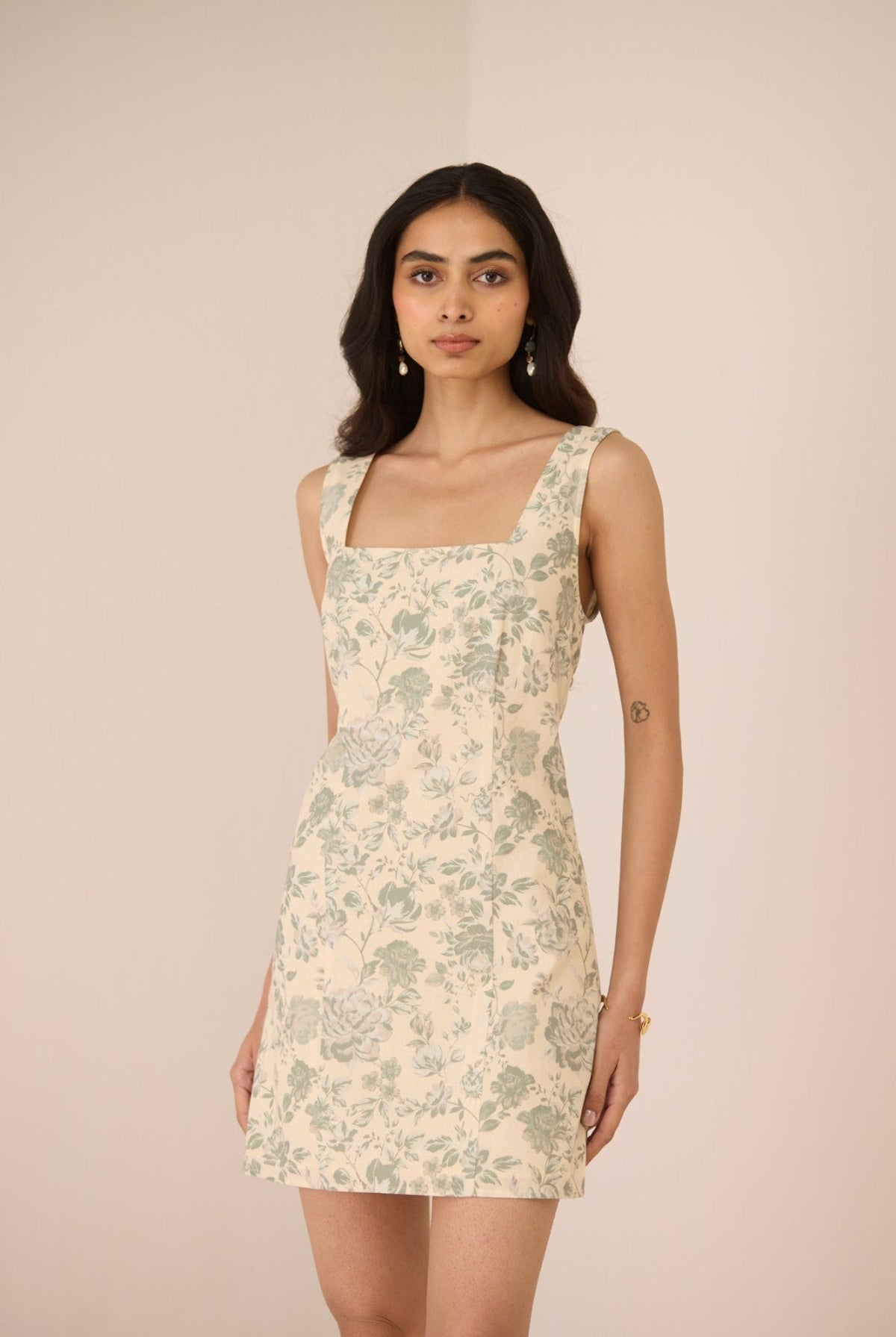 Woman wearing a floral dress against a plain background Calling June