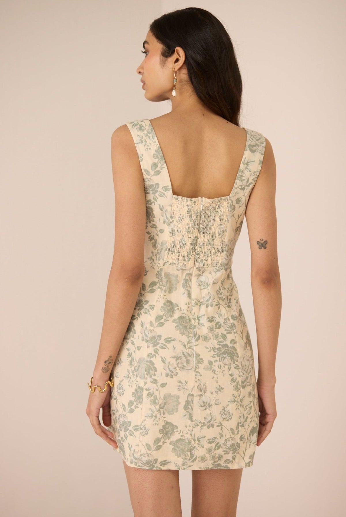 Woman wearing a floral dress with a beige background Calling June