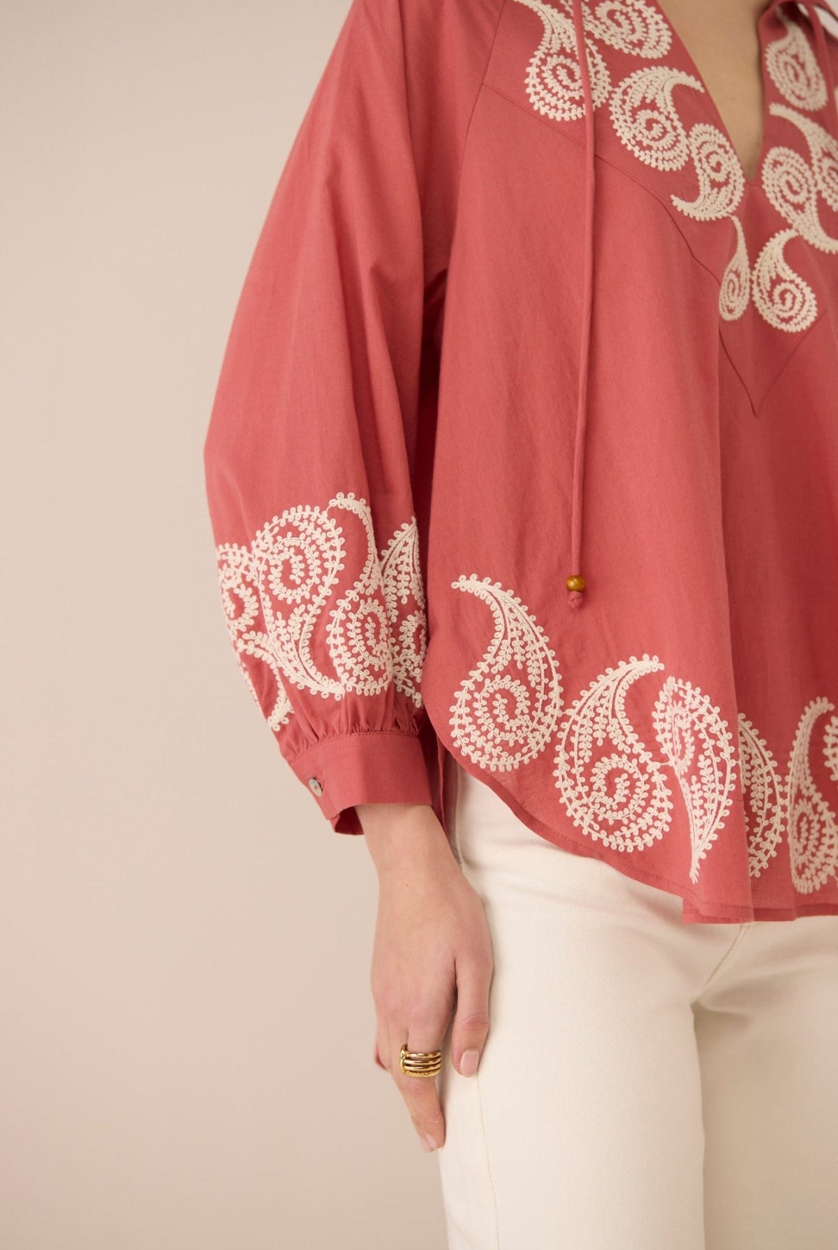 Red blouse with white embroidery on a beige background Calling June