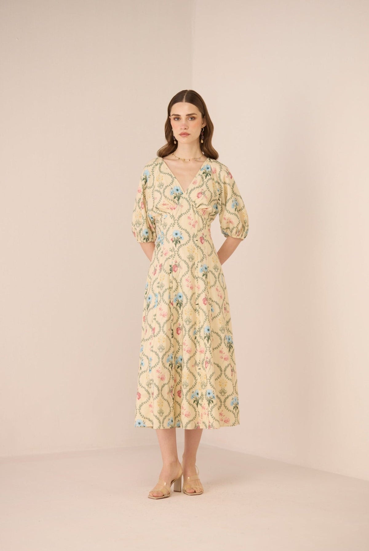 Woman wearing a floral dress against a plain background Calling June