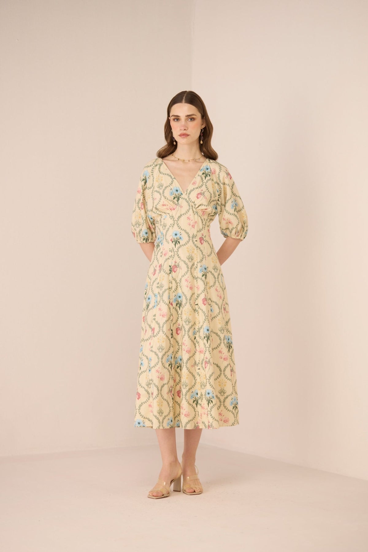 Woman wearing a floral dress against a plain background Calling June