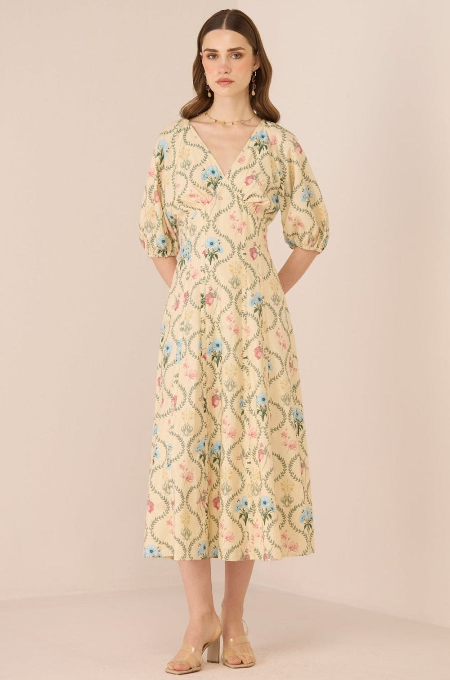 Woman wearing a floral dress against a plain background Calling June