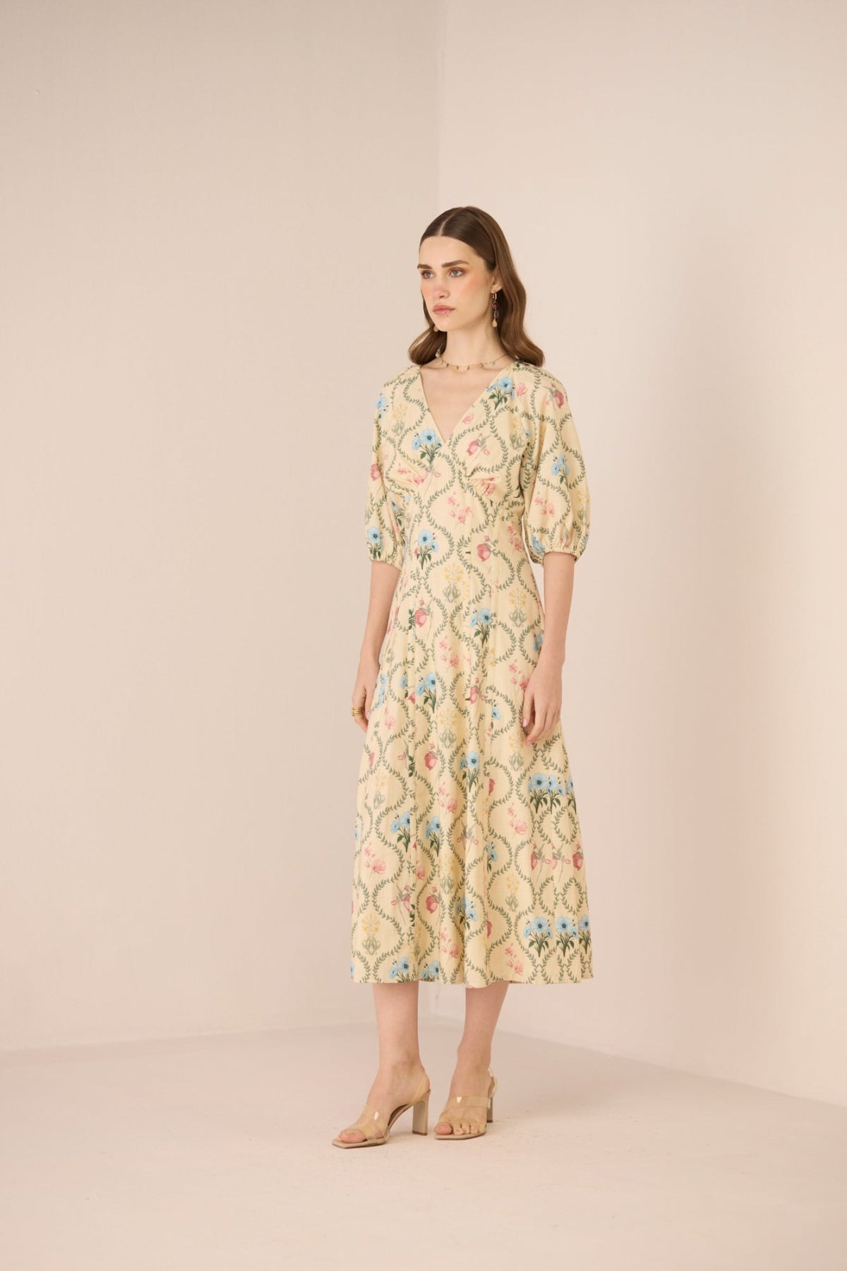 Woman wearing a floral dress against a plain background Calling June