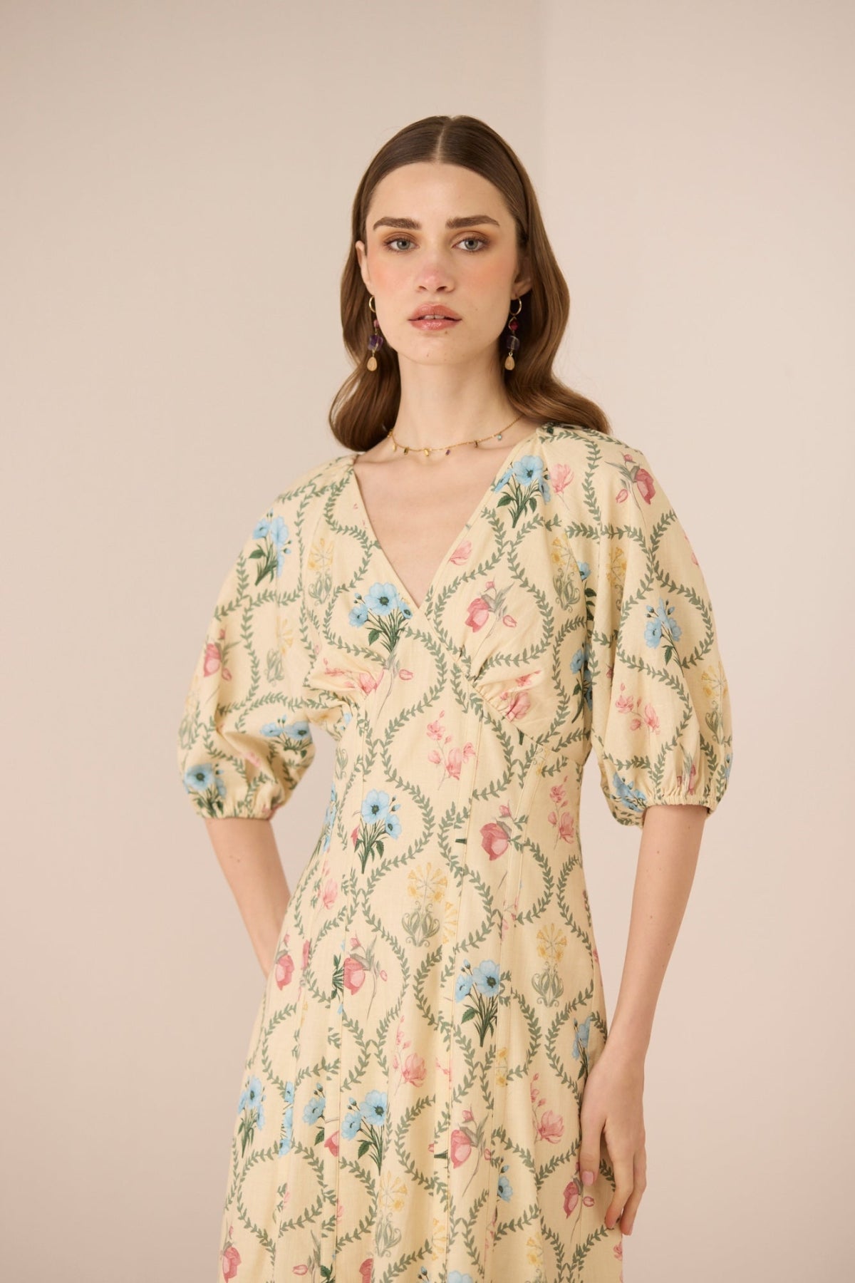 Woman wearing a floral dress against a beige background Calling June