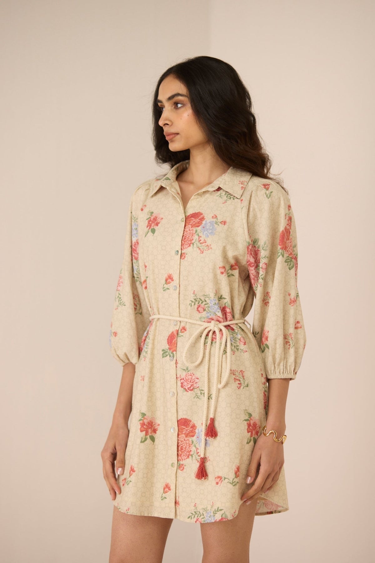 Woman wearing a floral dress with a beige background Calling June