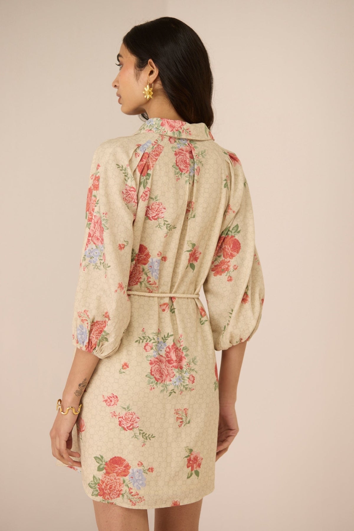 Woman wearing a floral dress with a beige background Calling June