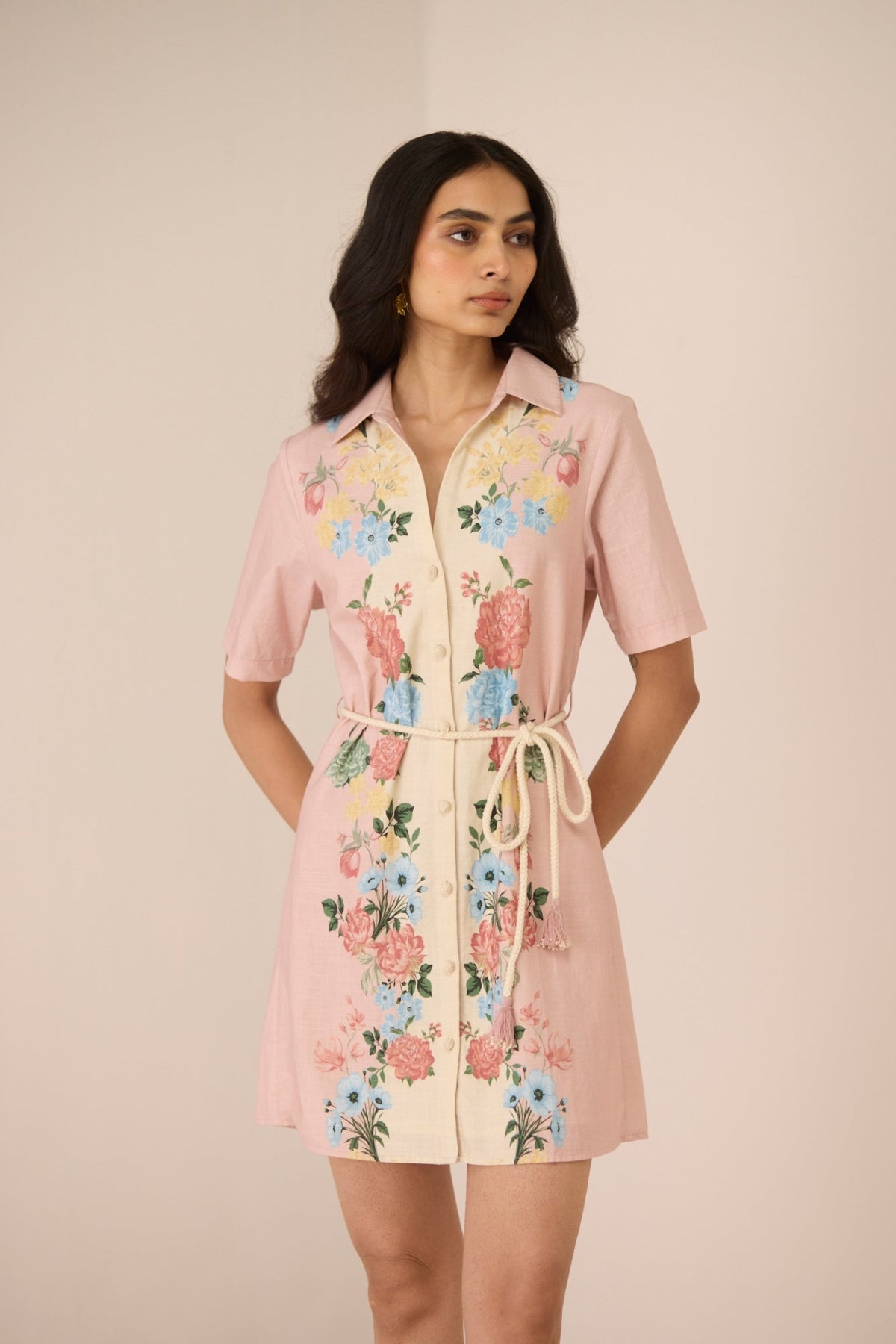 Woman wearing a pink floral dress against a beige background Calling June
