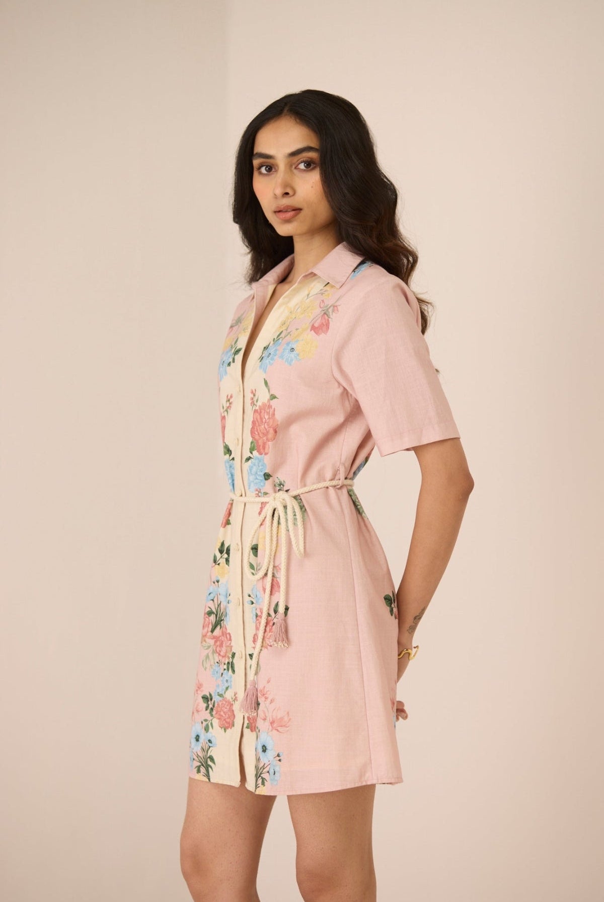 Woman wearing a pink floral robe against a beige background Calling June