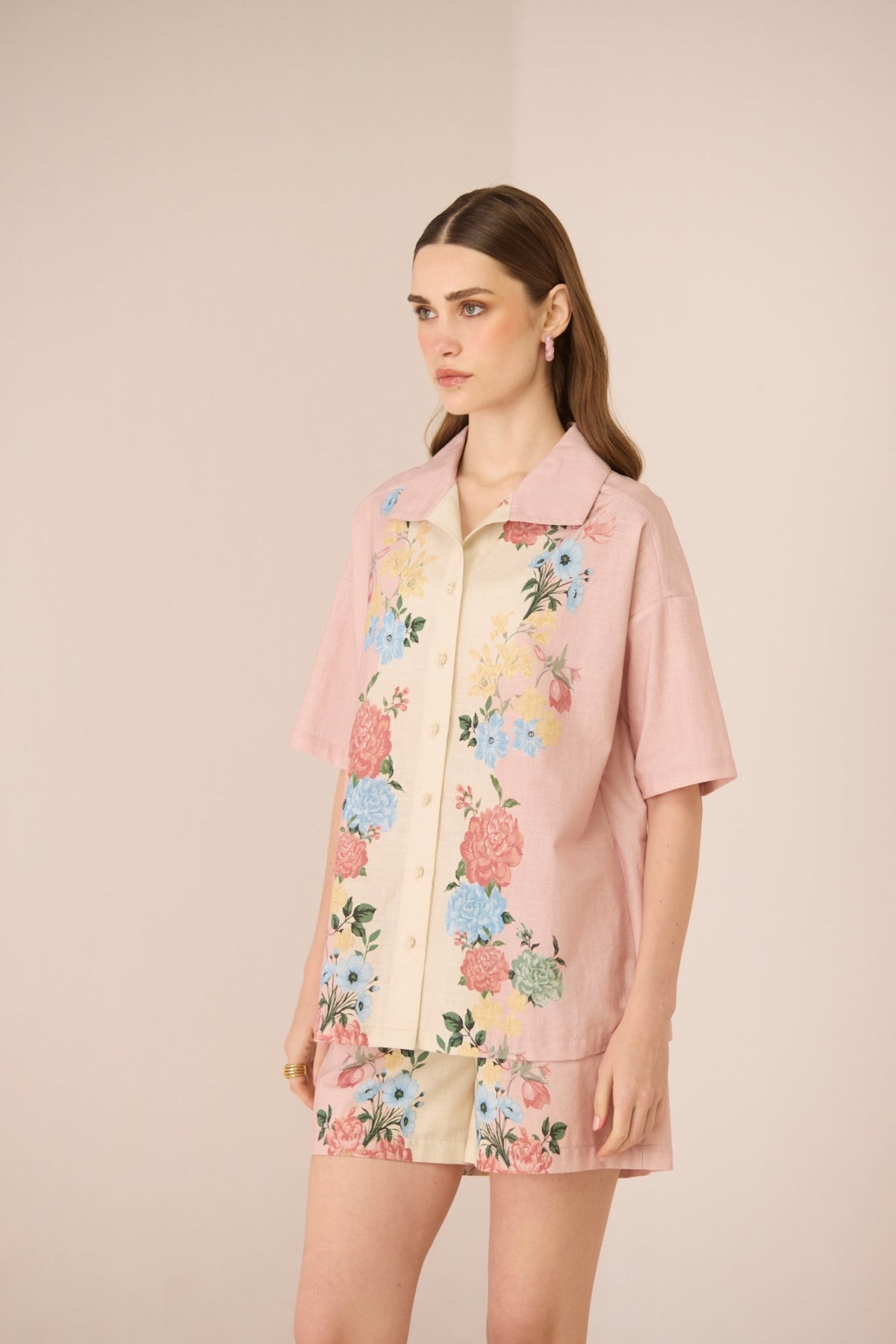 Woman wearing a pink floral outfit against a beige background Calling June