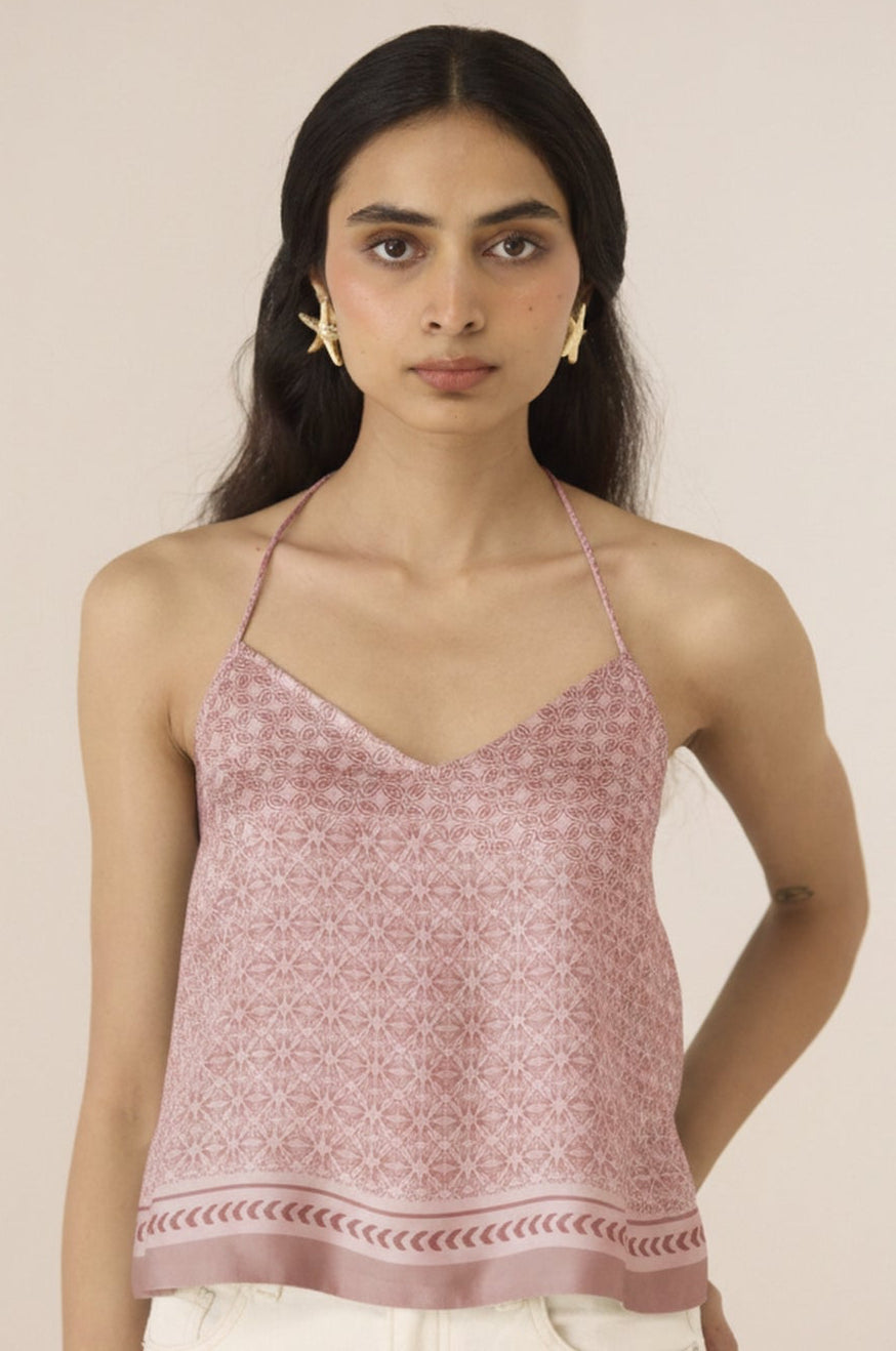 Woman wearing a pink patterned top against a beige background Calling June