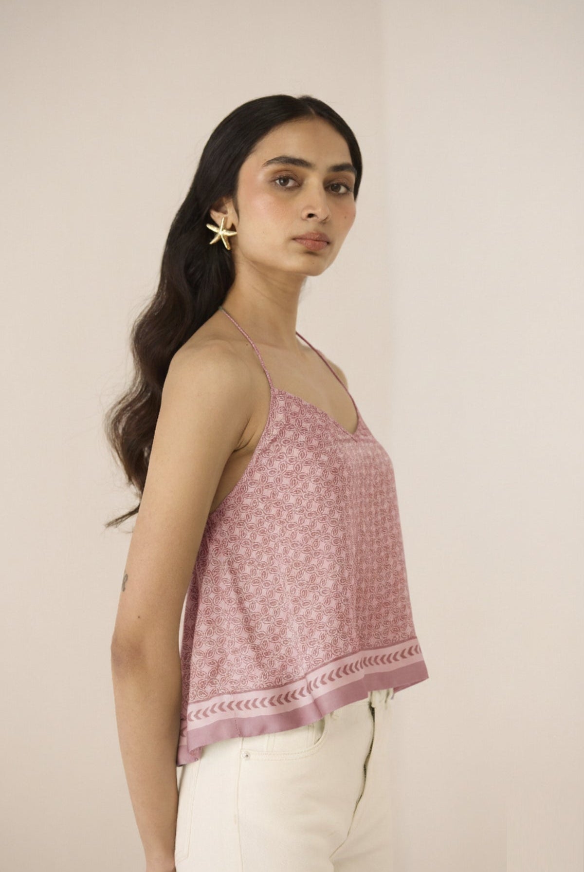 Woman wearing a pink floral top against a beige background Calling June