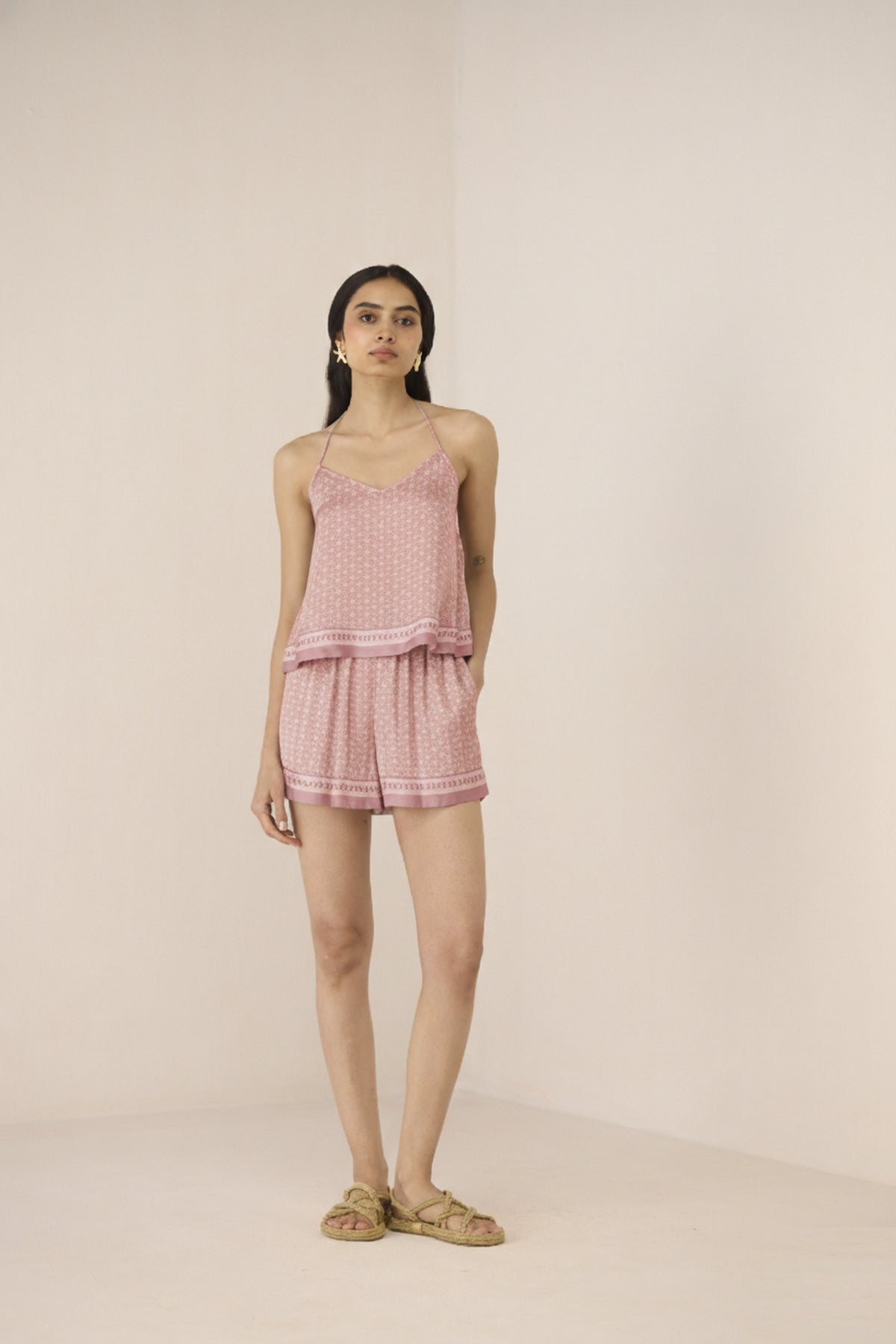 Woman wearing a pink checkered outfit on a beige background Calling June